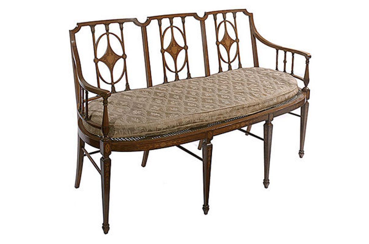 A satinwood framed 19th century Sheraton revival three seater settee with inlaid decoration.
The back with three diamond shaped splats, each inlaid with a classical urn.
The caned seat below with a removable squab.
The whole raised on freight