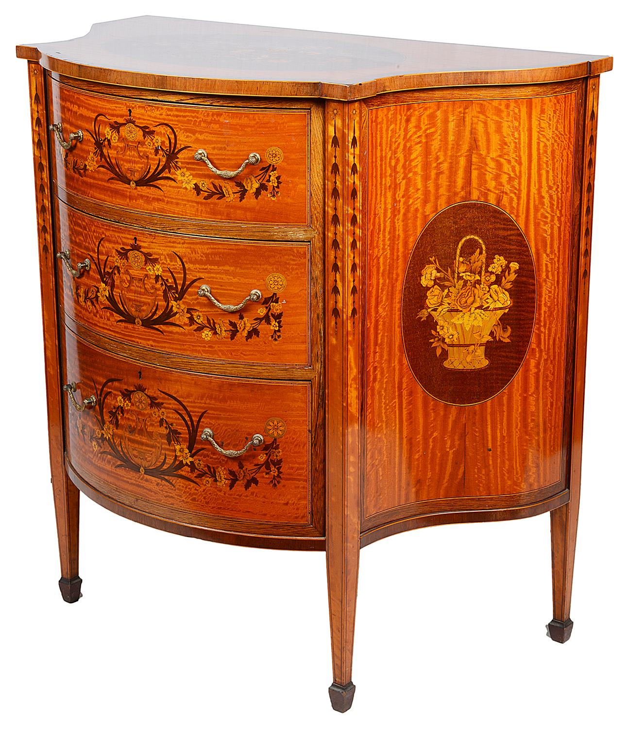 A very good quality late 19th century satinwood, Sheraton revival bow fronted commode. Having wonderful floral inlaid decoration to the oval panel on top, the three, oval inlaid panels with baskets of flowers to the sides and raised on square