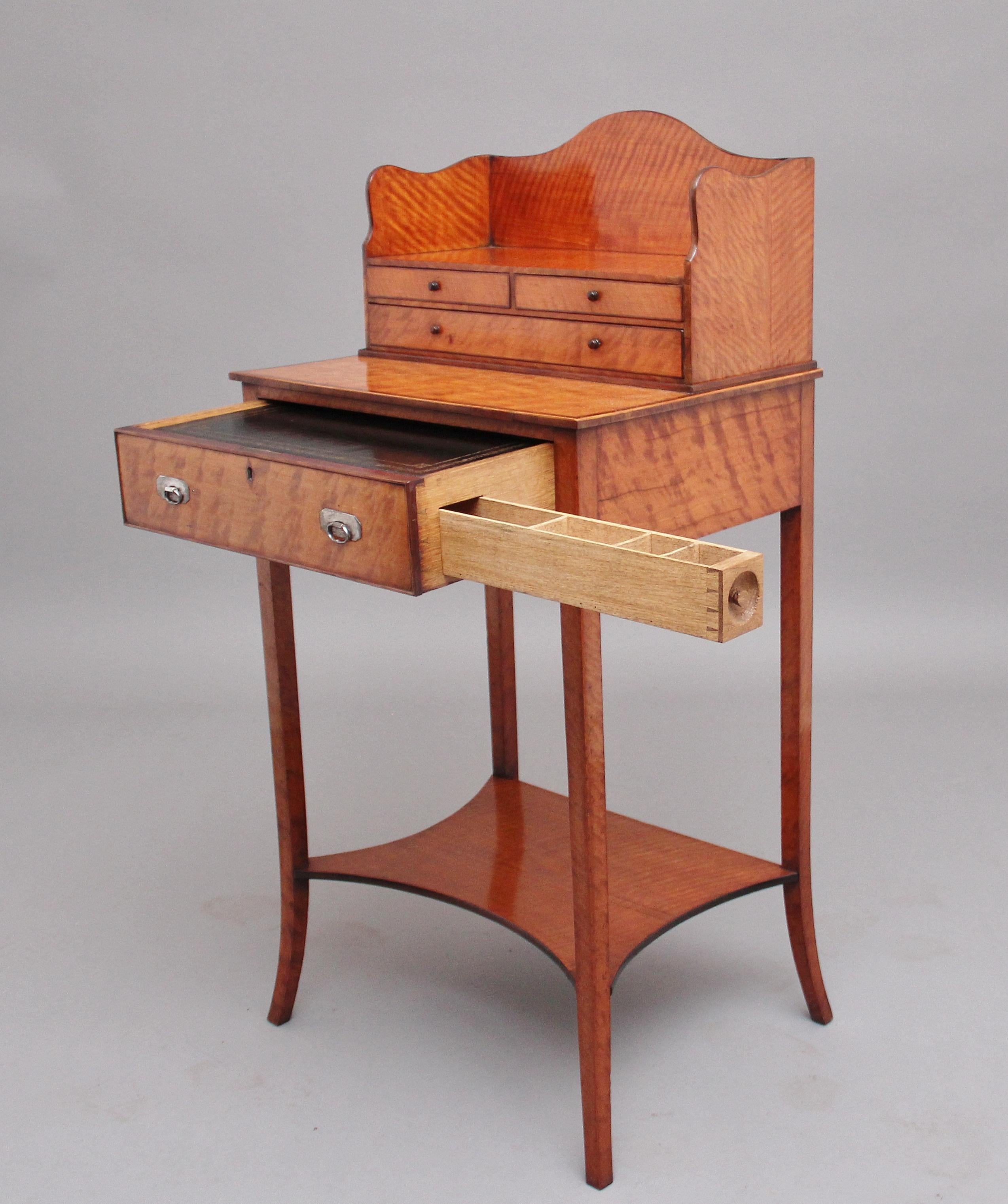 A super quality 19th century satinwood ladies writing table in the Sheraton style, having a shaped superstructure with two short over one long oak lined drawers with original turned wooden knob handles, the base section having a single drawer with