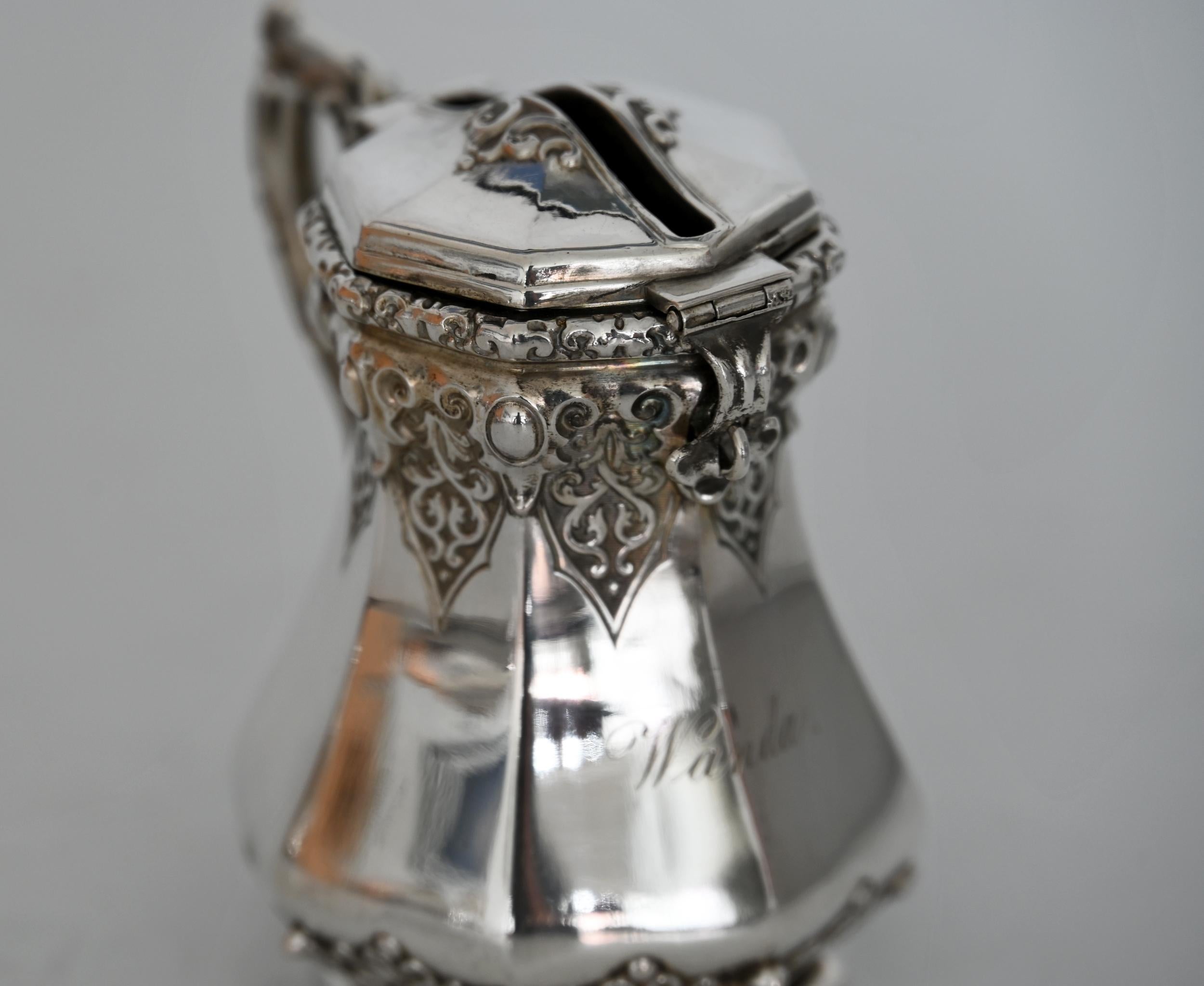 Beautiful small piggy bank from the Biedermeier period in silver 13 lot.
Decorated with rocailles and leaves, beautifully worked out; in front a finely engraved monogram with the first name Wanda,
The wonderful bank is in very good condition.