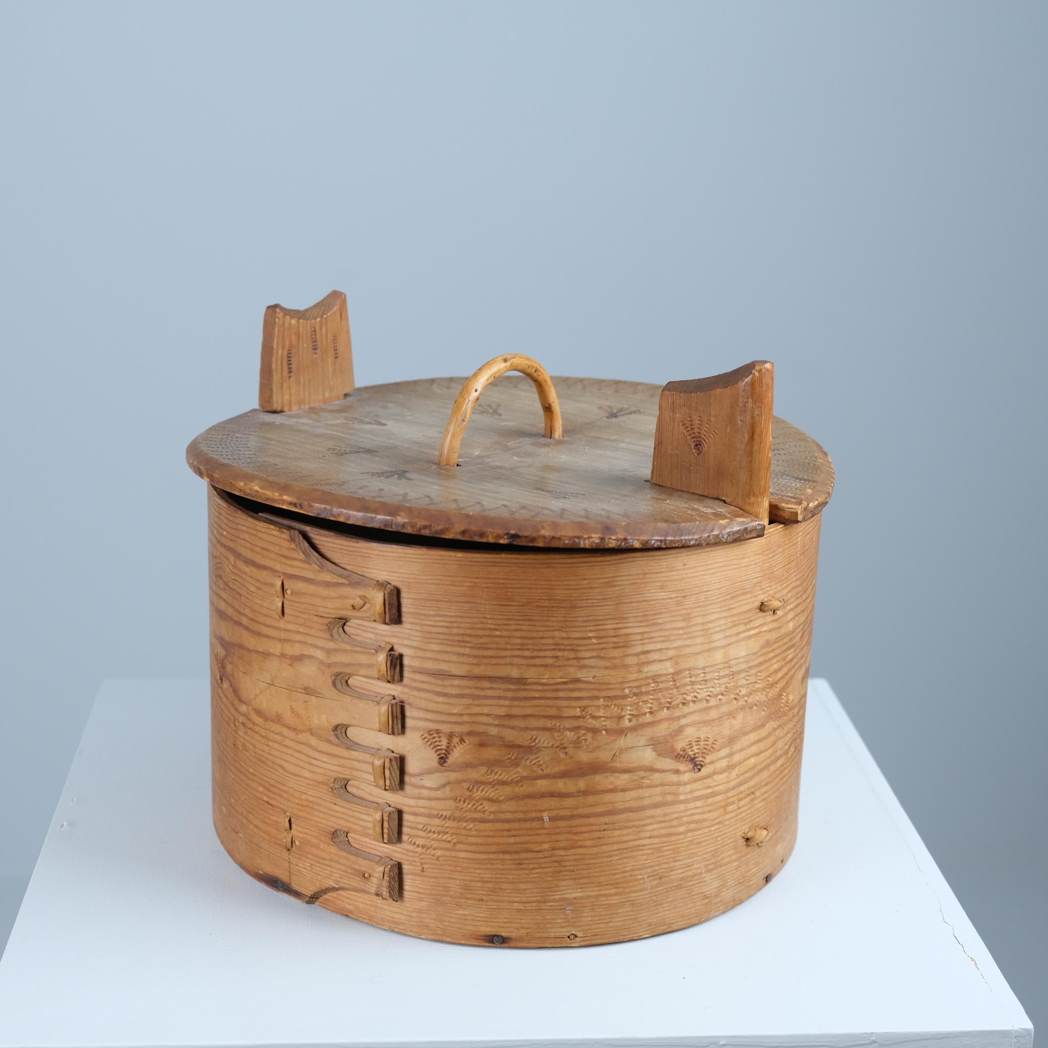 Una bella svepask (scatola di legno curvo) di arte popolare scandinava, probabilmente svedese, con coperchio, tra la fine del XIX e l'inizio del XX secolo. Realizzata in pino con splendidi dettagli, questa scatola tradizionale è realizzata con la