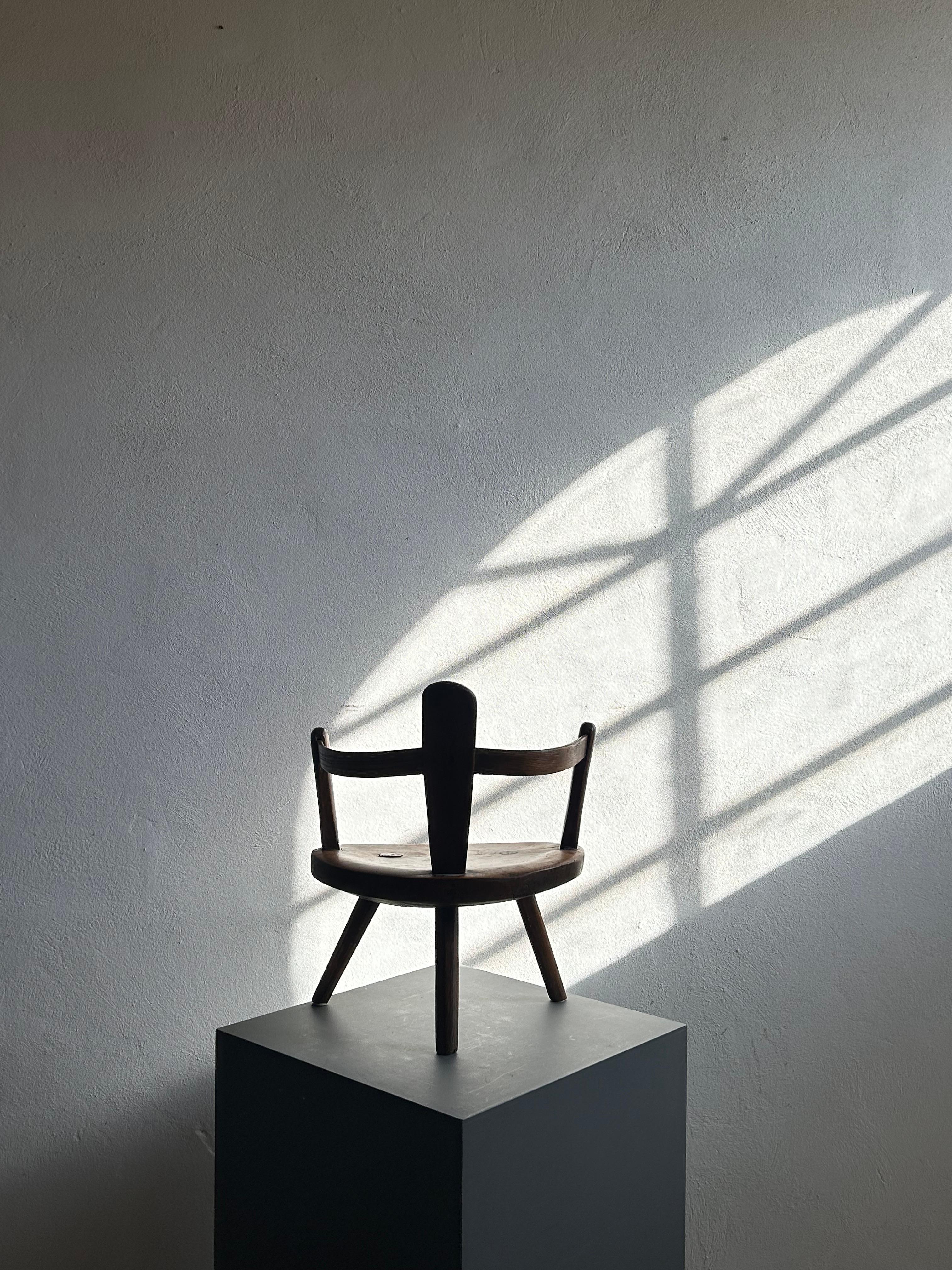 Une chaise d'enfant scandinave rare et magnifiquement primitive, sculptée à la main dans du bois massif avec une patine et une usure incroyables dues à des siècles d'utilisation. La forme à la fois naïve et sculpturale de la chaise reflète l'essence