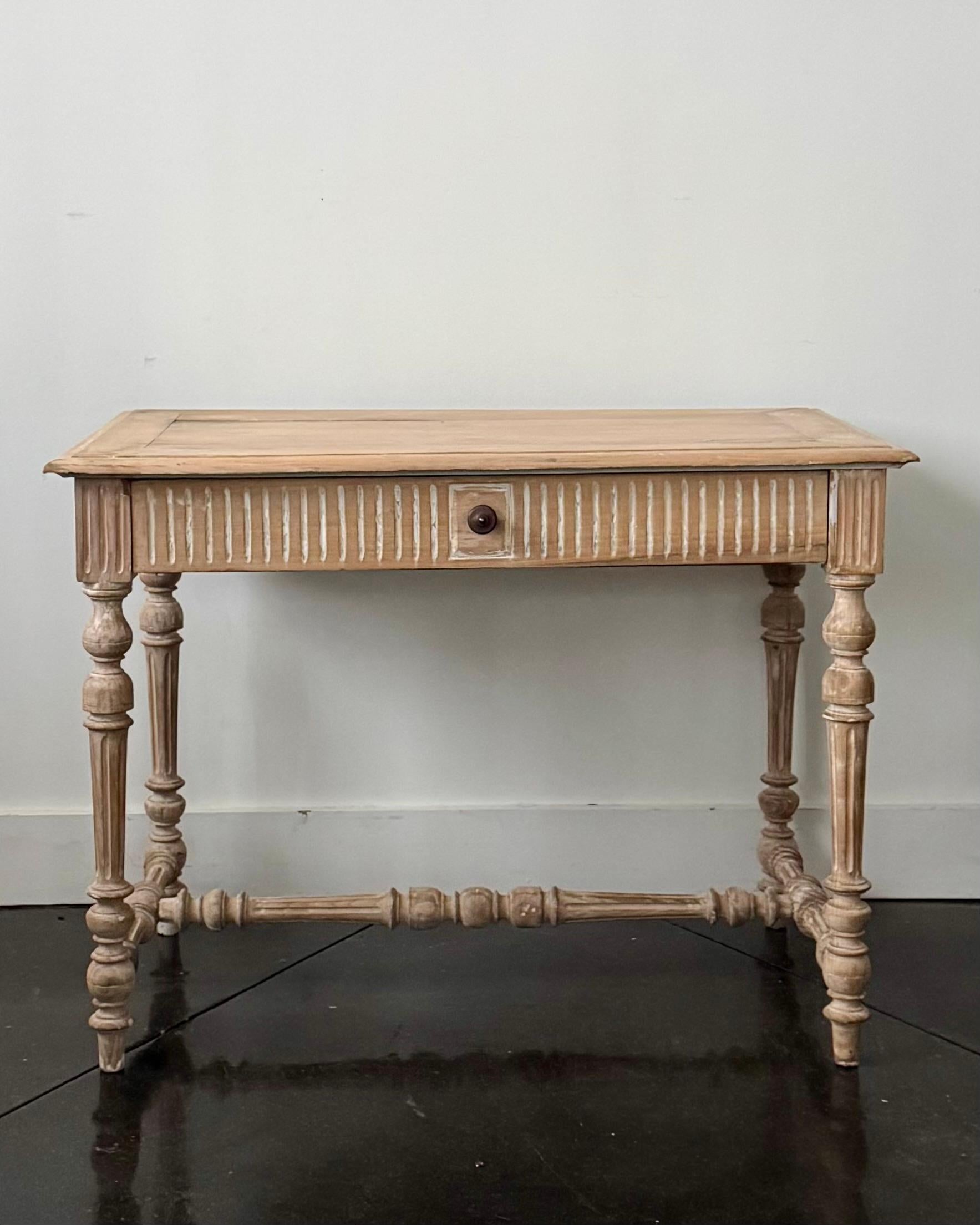19th century Scandinavian Neoclassical console table with one drawer and carved fluted decor around the apron on all four sides. Stands on four turned legs joined by bottom carved strechers.
The table is scraped from multiple layers of mix old paint
