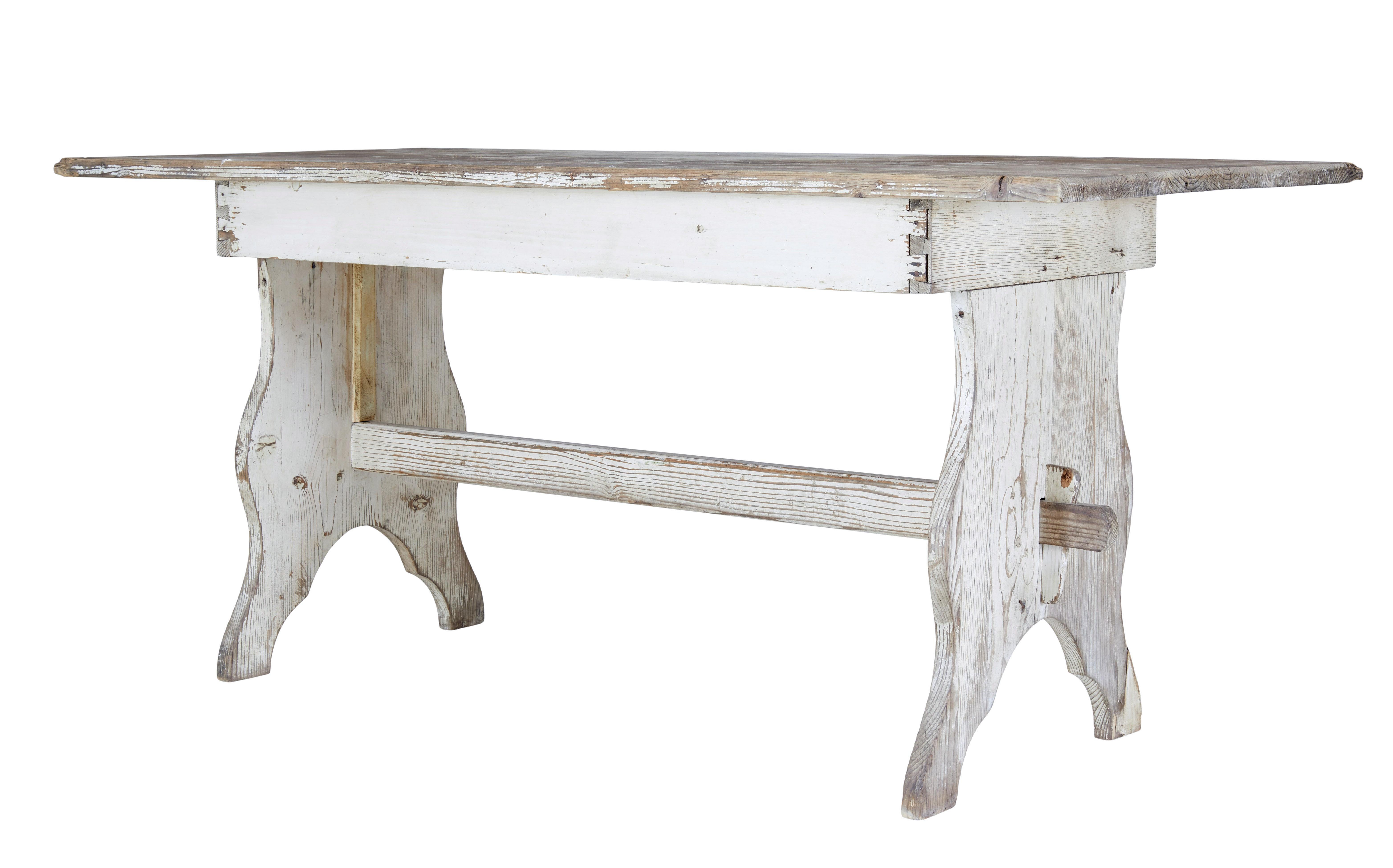 19th Century scandinavian painted pine dining table circa 1880.

Good quality swedish pine trestle end table, which could be used for dining or as a desk.

Rectangular pine plank top with traces of original paint, supported by a dove tailed