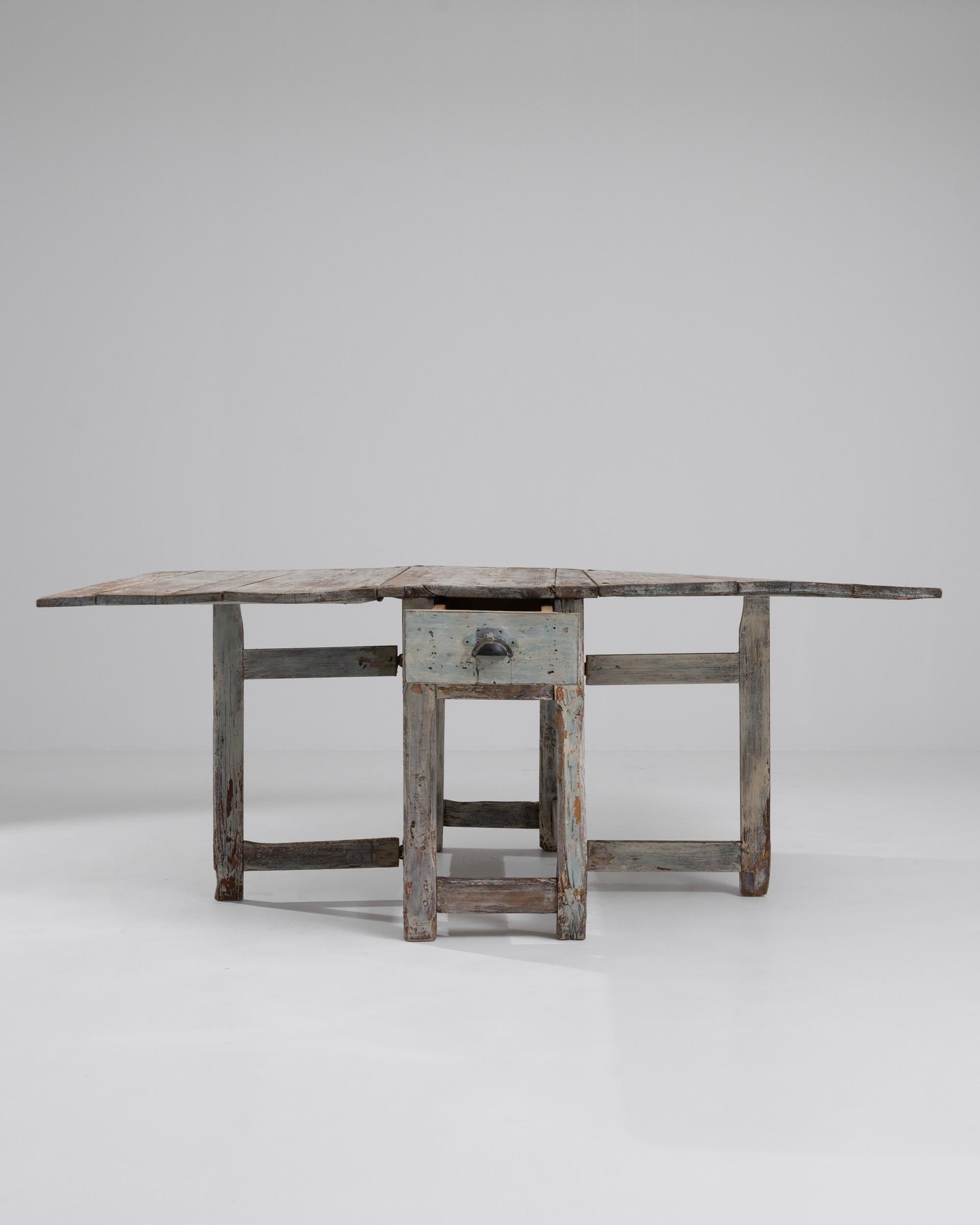 Dieser rustikale Holztisch, der um 1800 in Schweden hergestellt wurde, strotzt vor Persönlichkeit. Das Design ist einfach und doch vielseitig: Die breiten Flügel der Holztischplatte können geschlossen werden, um eine schmale Einheit zu bilden, oder