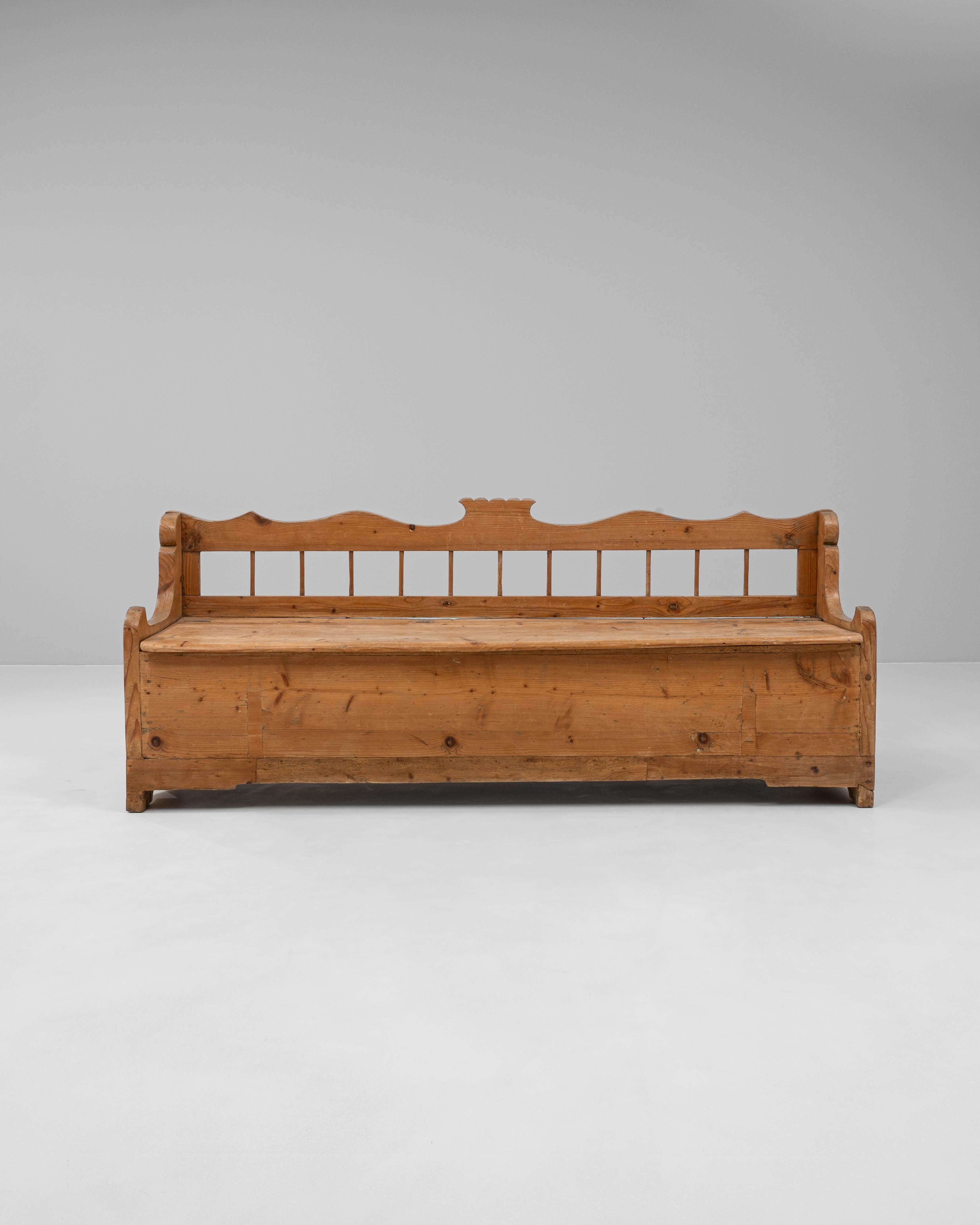 Este banco de almacenaje de madera escandinavo del siglo XIX combina el encanto antiguo con una función práctica. Fabricado en pino macizo con una cálida pátina de tono miel, presenta un respaldo bellamente tallado con bordes suavemente festoneados