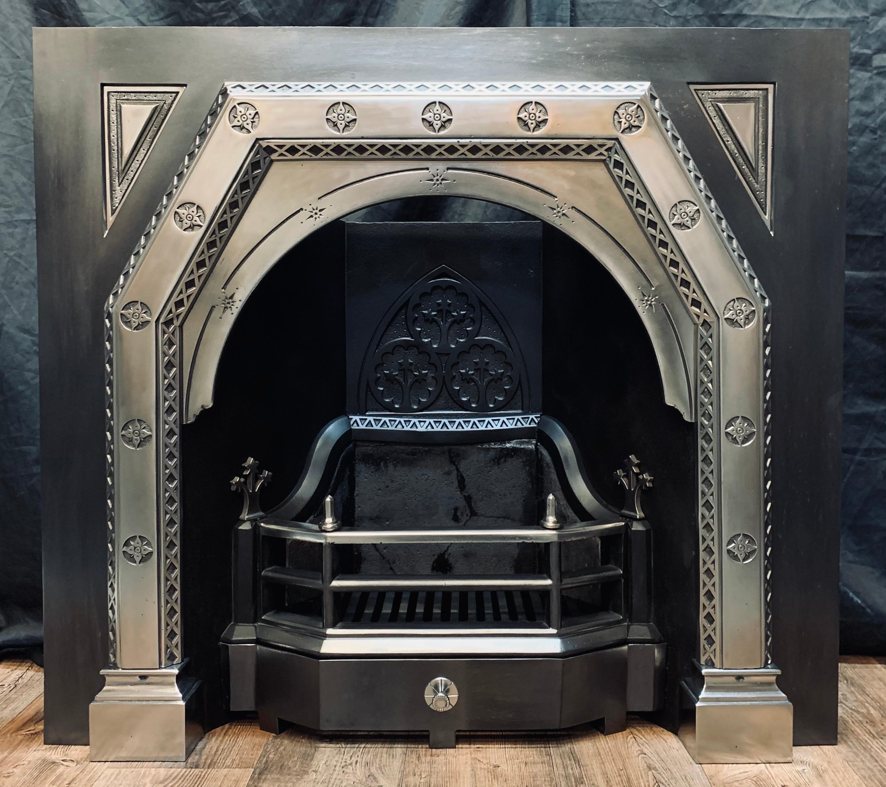 A large masculine and flamboyant example of a 19th century Scottish Aesthetic movement cast iron fireplace insert. A large outer plate with recessed fielded panels hosts an off set protruding polished front, with 13 cast daisies and repeating