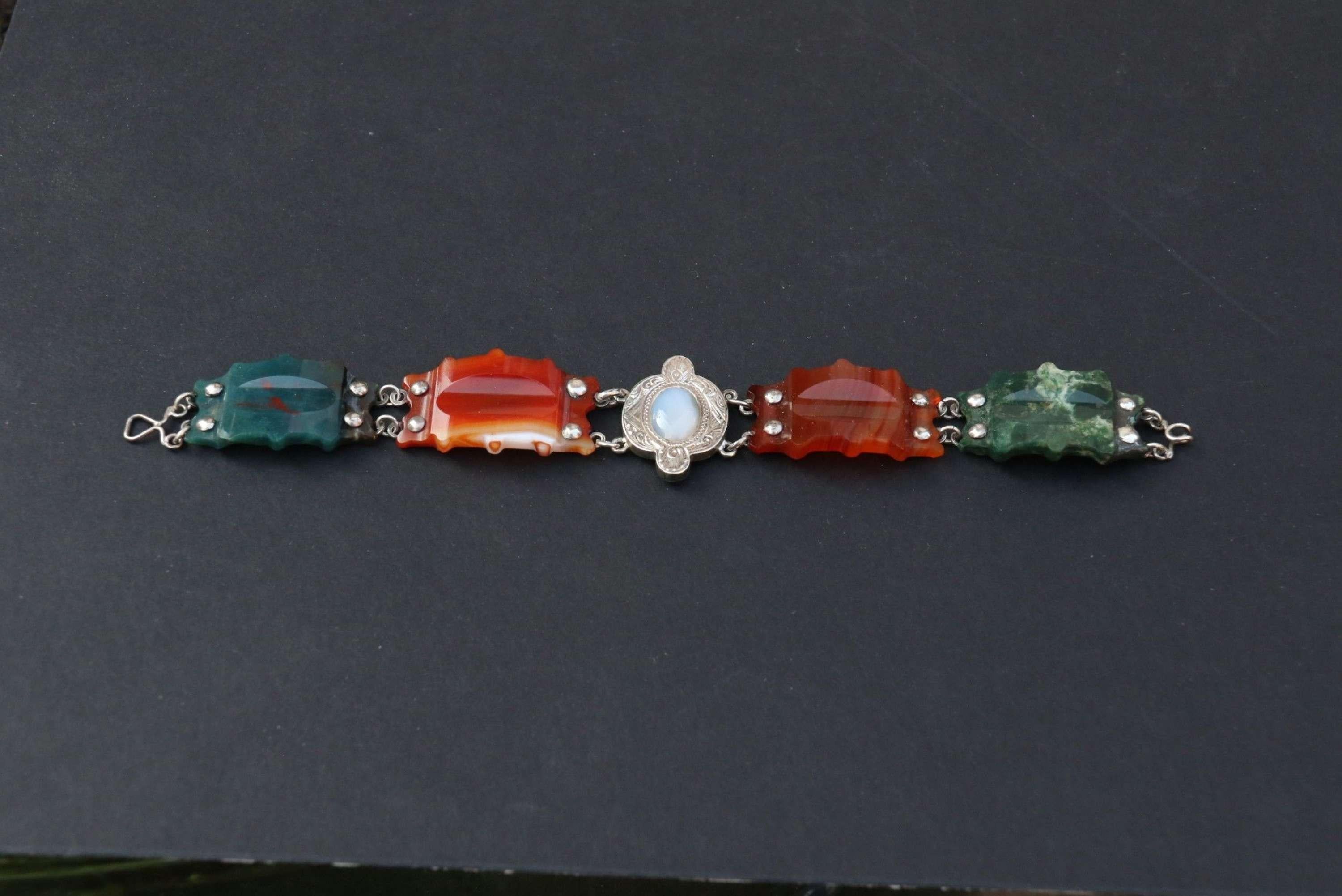 A Superb Scottish Agate and silver bracelet

This beautiful Scottish agate bracelet Is made from alternate figured green and orange agate carved and shaped panels with a silver engraved centre piece set with an oval white agate. These sections are