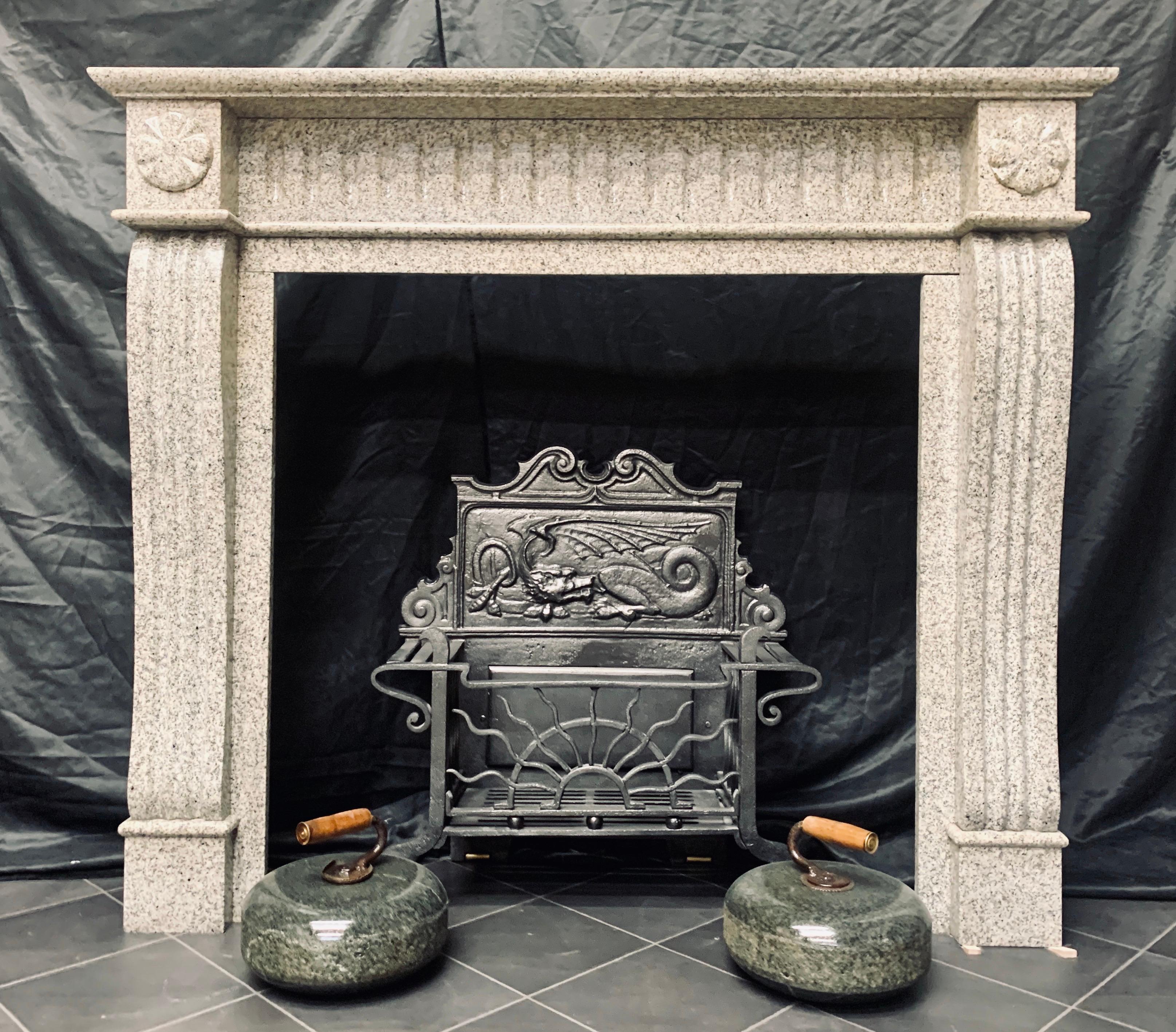 A noble 19th century Scottish Baronial style fireplace surround carved in Kemnay Granite. A moulded shelf sits above a frieze with vertical flutes, flanked by capitols decorated with circular carved Celtic crosses, resting in turn on large sweeping