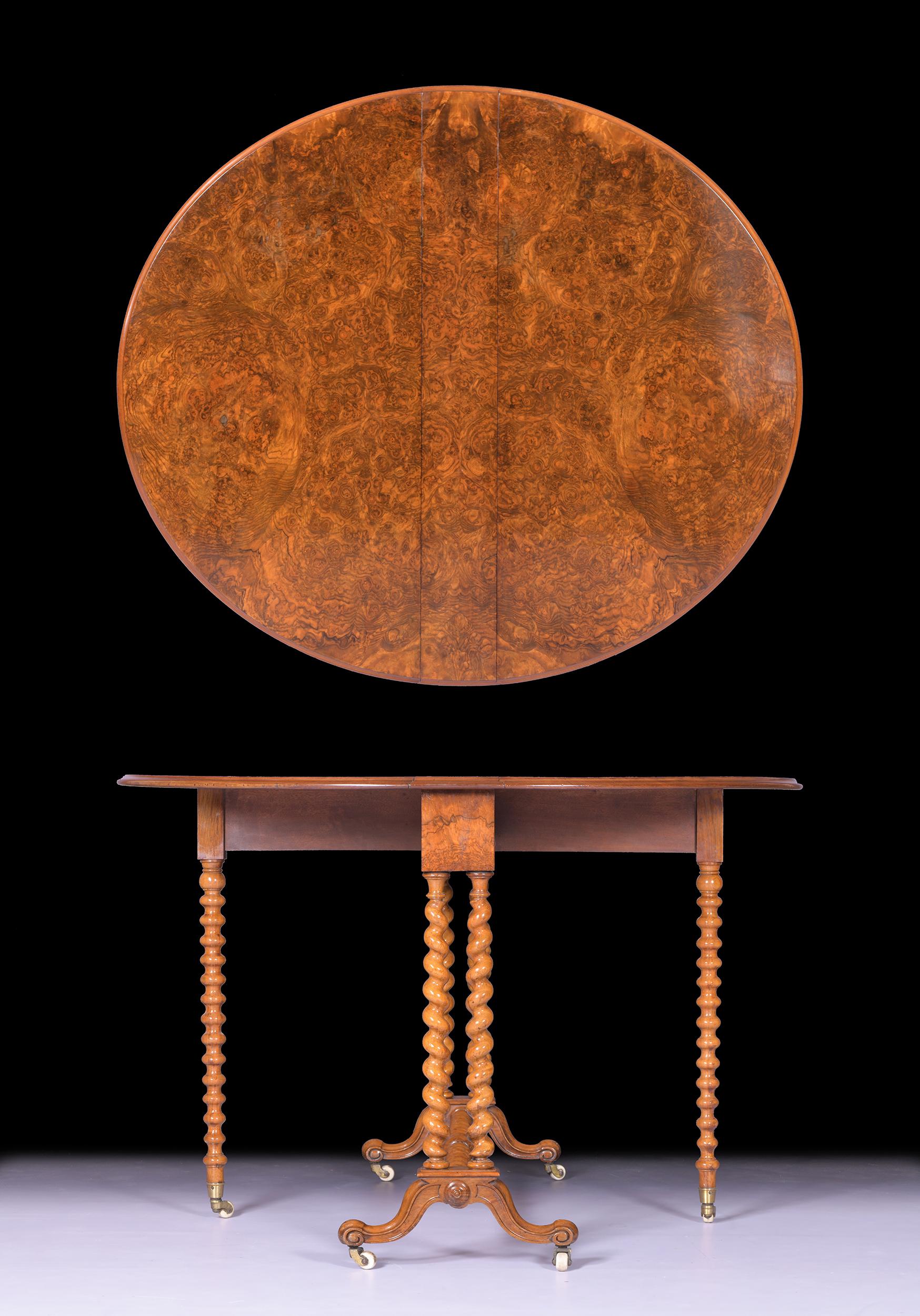 Constructed in a fine quality burr walnut the oval top with drop sides and a moulded edge raised on barley turned legs joined by a bobbin turned stretcher, on scroll trestle feet, the gate legs with porcelain castors. Stamped & No. John Taylor,