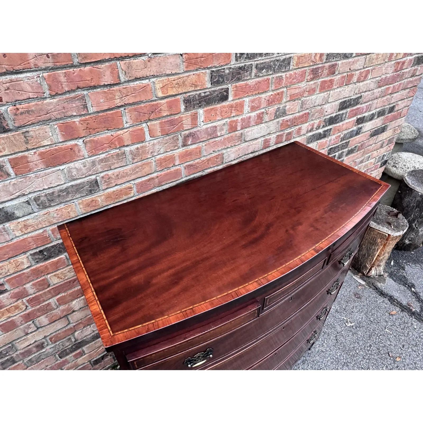 Una cassettiera a prua in mogano a fiamma e intarsiata del primo Ottocento, con il piano sagomato a figure che sovrasta quattro cassetti graduati con due cassetti nascosti a destra e a sinistra nella parte superiore. Circa 1830.
I cassetti scorrono