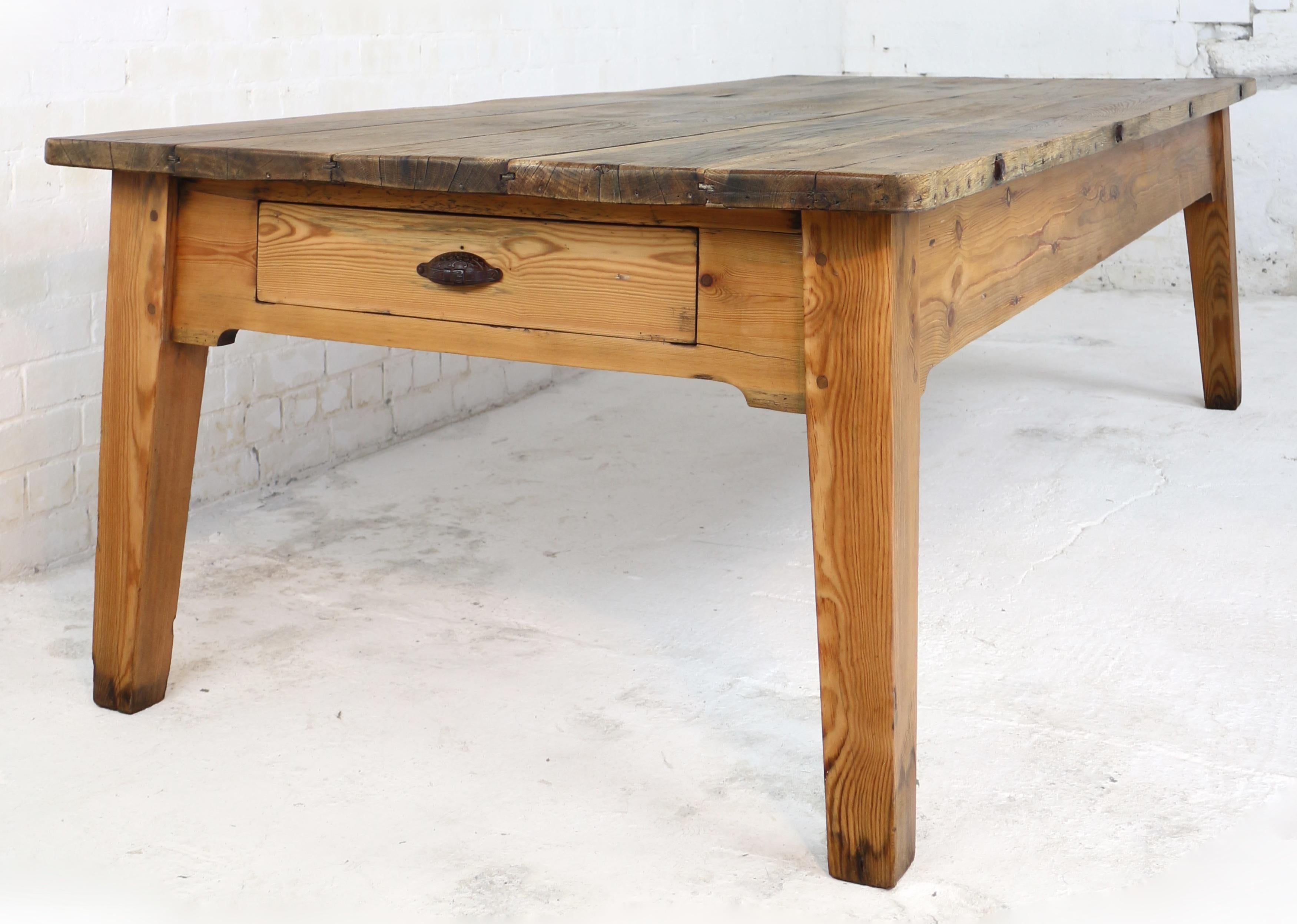 A superb large Scottish Estate preparation table with a planked oak top and pitch pine base on stout outsplayed tapering legs. With five 1½in thick oak planks to the top, the pitch pine base of pegged construction with a shaped apron, single drawer