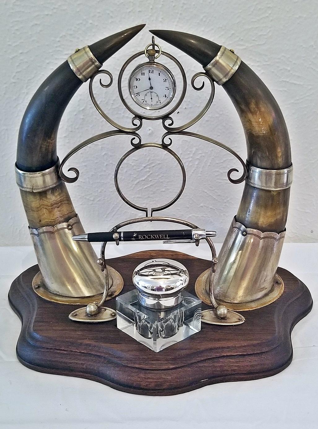 Ink Standish with solid oak base, two Highland cow horns form the centrepiece of this unusual and gorgeous display, leading to two rings for Pocket Watch & Fob display.

The horns are banded in old plated silver and the stand for writing pens or