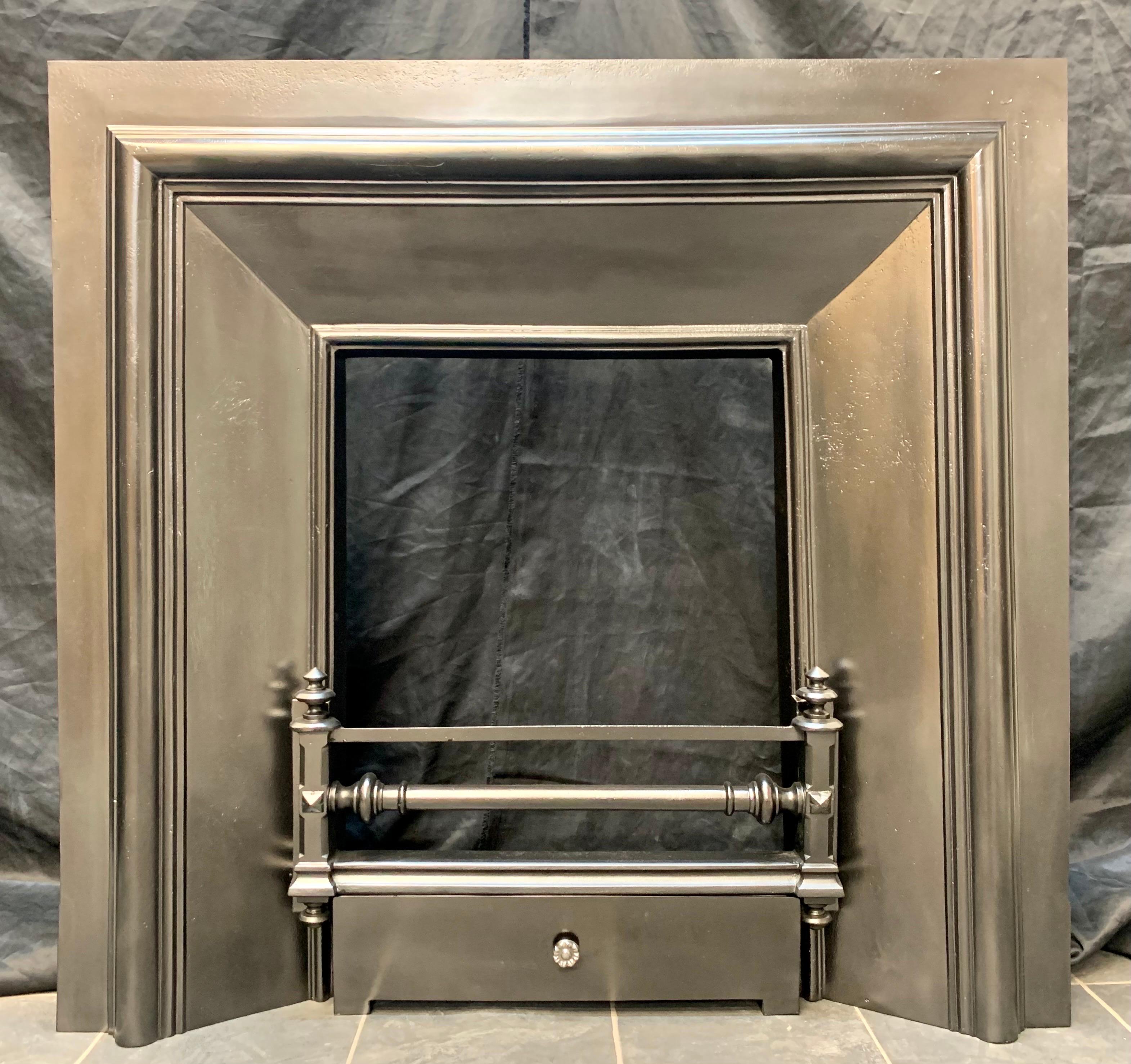 A simple 19th century Scottish splayed cast iron fireplace insert. A generous outer plate, with a projected raised moulding to the outer aperture and inwards splayed side panels, a three barred fire front with finishing finials top and bottom, plain