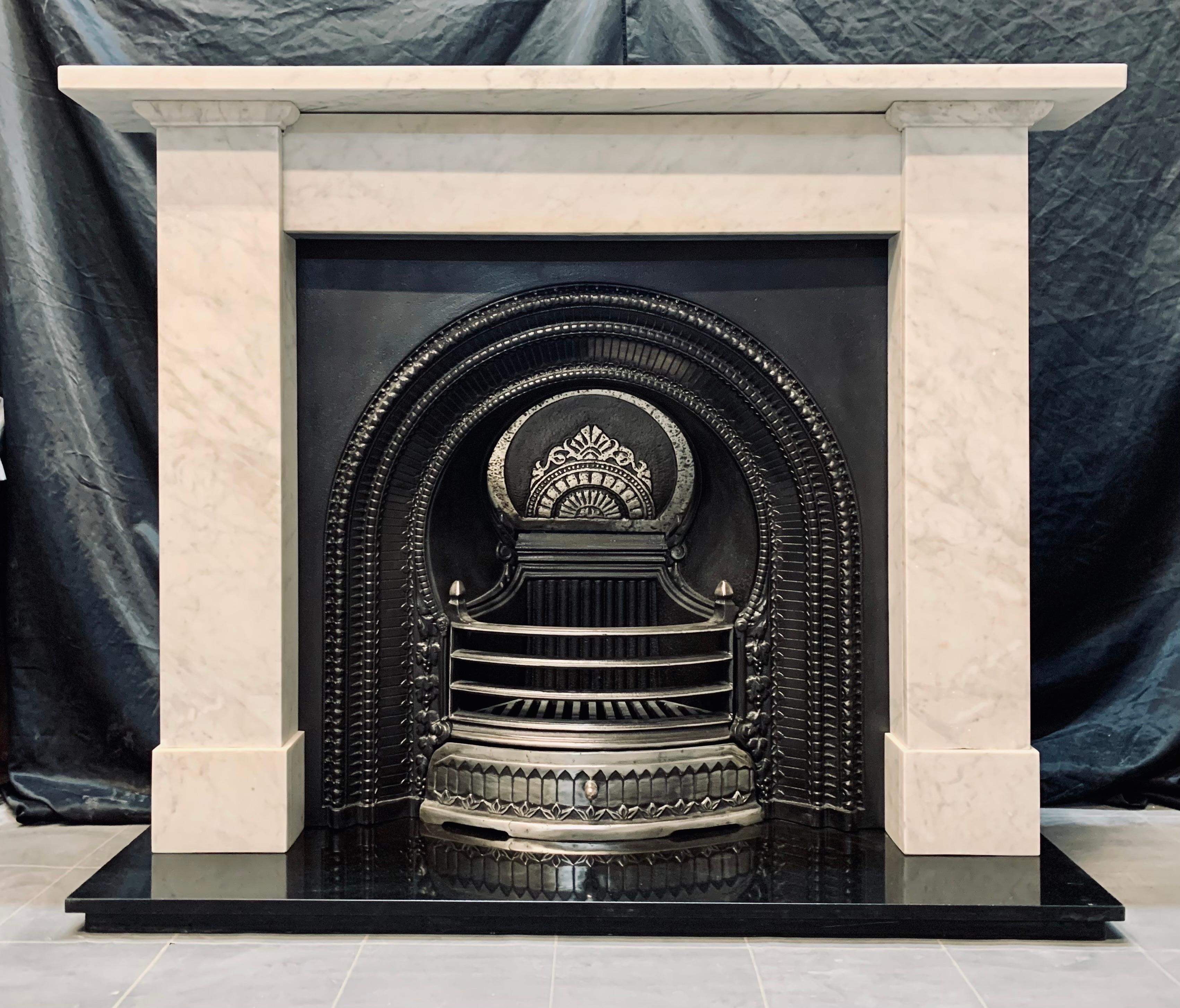 A Scottish 19th century Victorian lightly 
veined Carrara marble fireplace surround
A classic Scottish design in a prominent
well figured marble. A square shelf sits
above an unadorned frieze, flanked by tall
jambs with moulded capping to the top