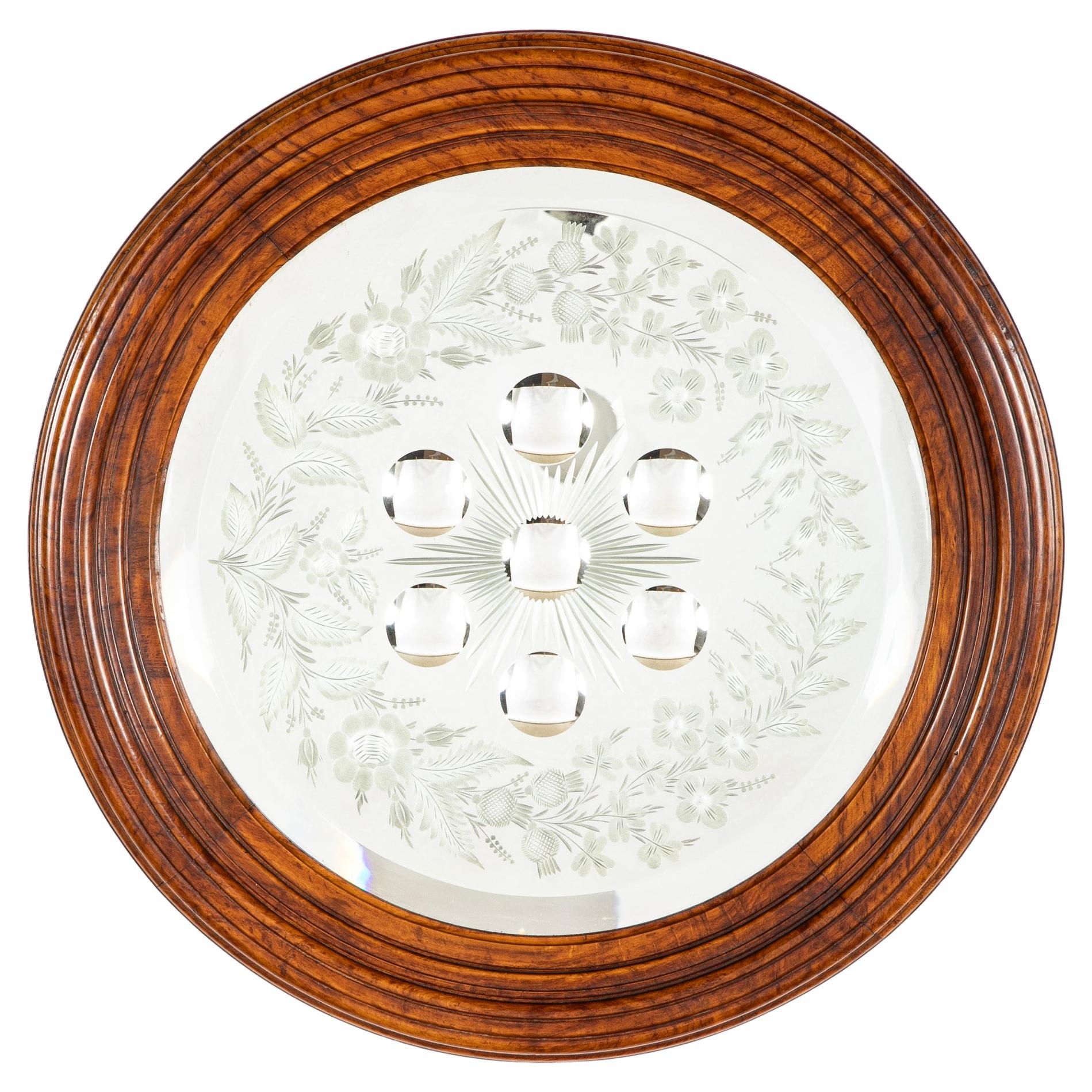 Rare Scottish elm wood mirror, the beveled glass etched with thistles and roses, the center with seven mini convex circles amidst a starburst. The elm wood frame with lovely grain and glowing patina. You won't find another one. 
19.75 inches