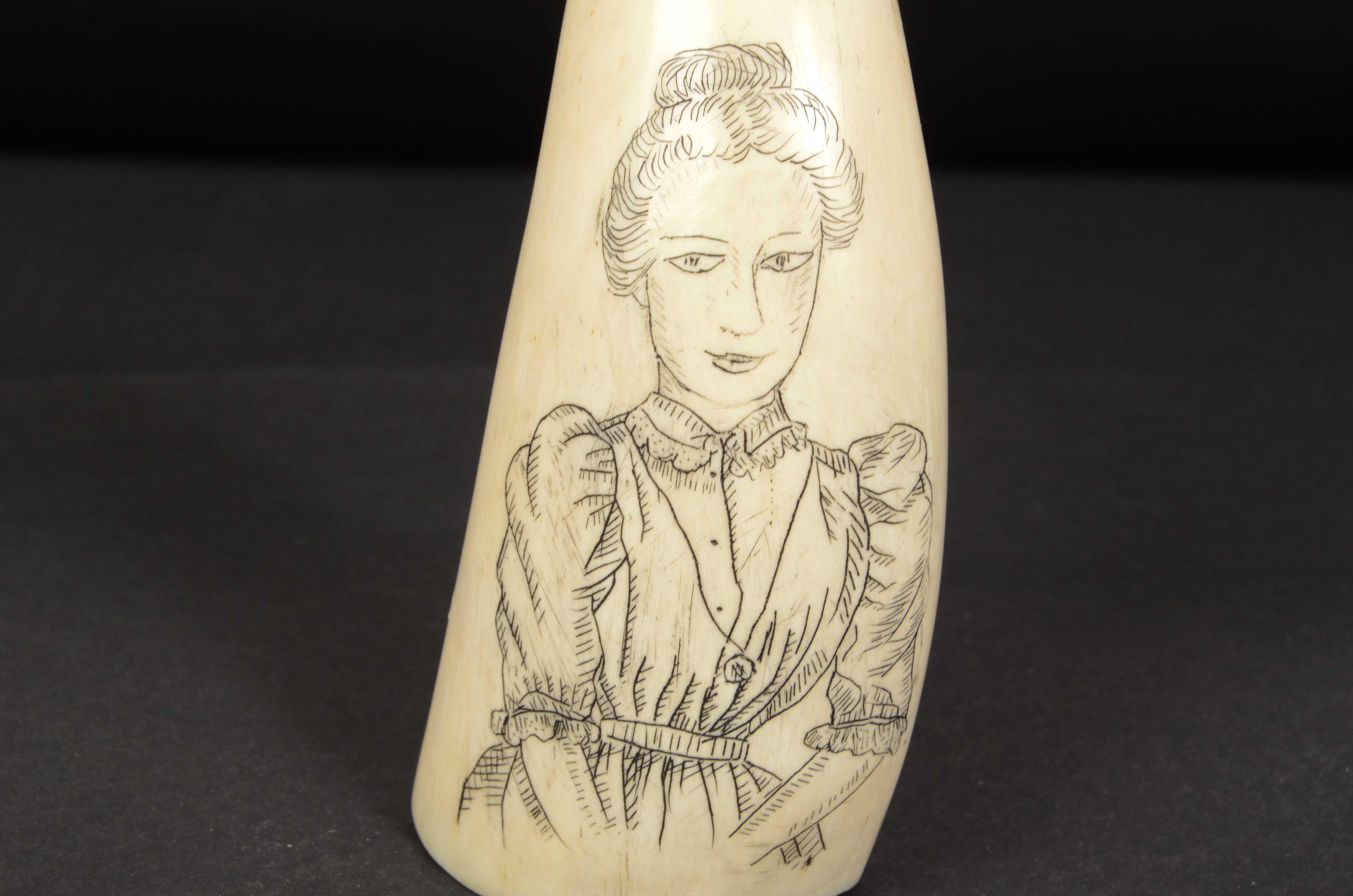 Scrimshaw of a vertically engraved whale tooth, of exquisite workmanship, length 12.6 cm, depicting the bust of a Woman and on the back a whale and whalers at sea with the boat overturned. 
Very good condition. Measurements 12.6x5x3.8 cm -