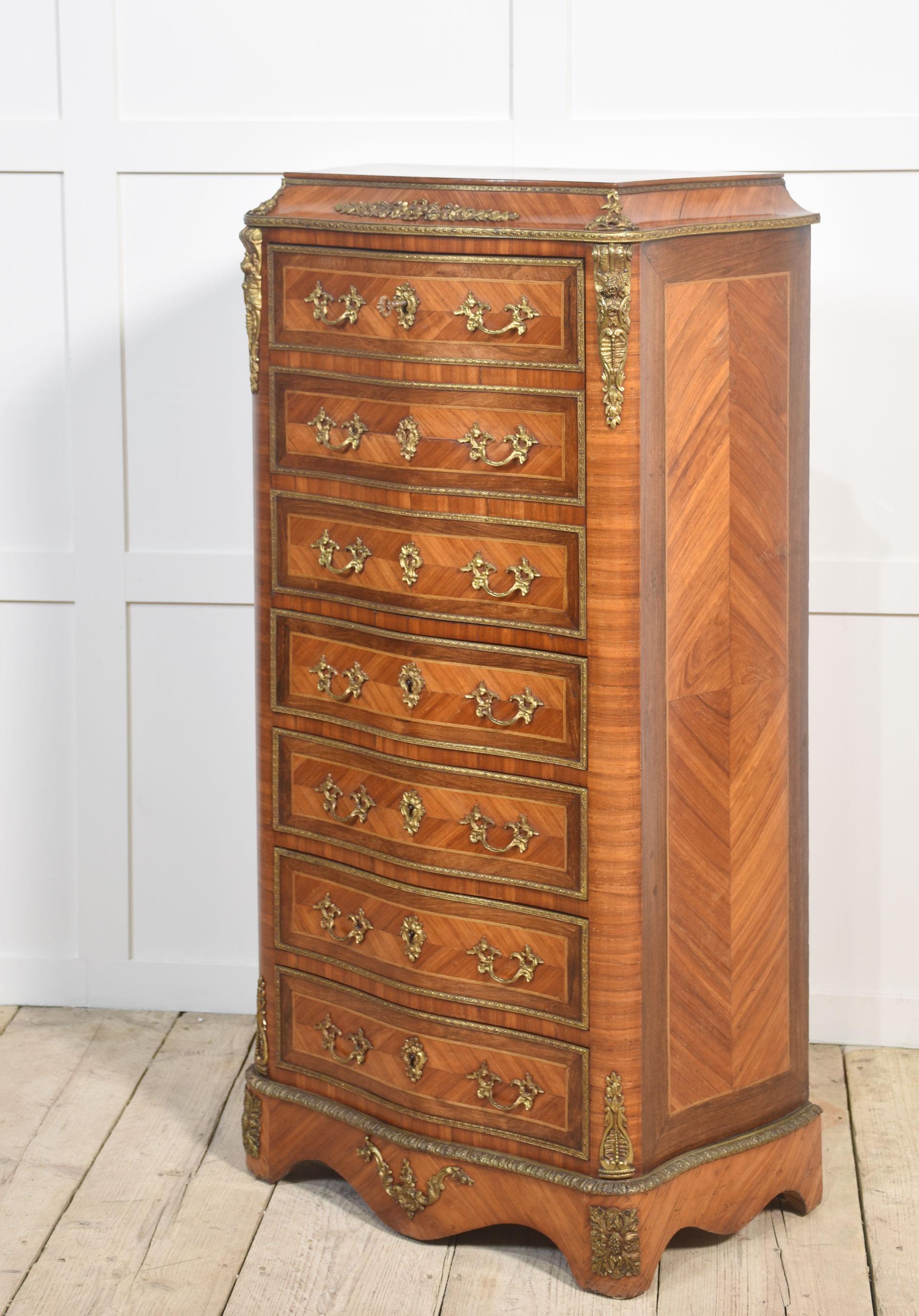 A French secretaire a’ abbattant, in the Louis XVI taste, the well-figured top, above conforming serpentine front over a fall front secretaire, enclosing drawers and shelf with a green tooled leather writing surface, above four further drawers, all