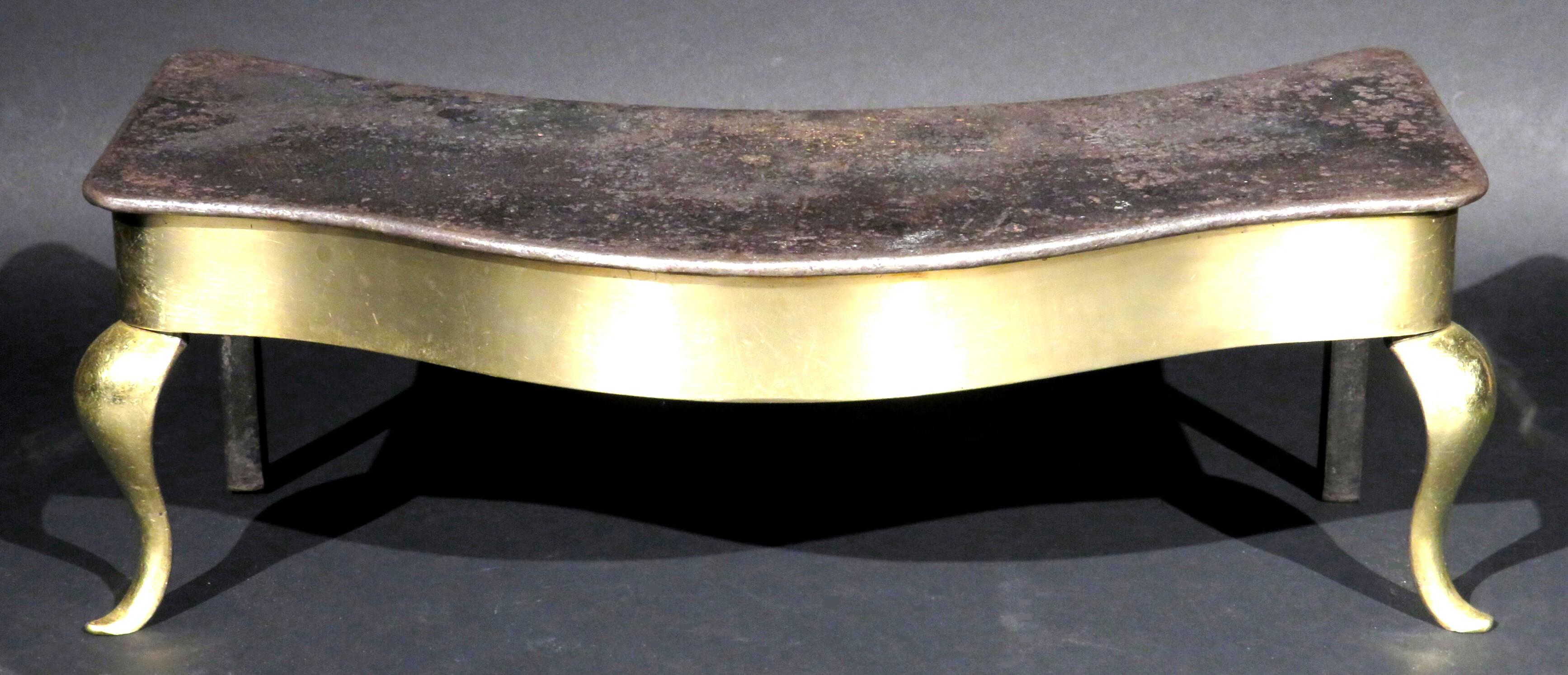 A most unusual form, showing a serpentine shaped iron platform fastened to a conforming substantial brass base, raised overall upon squared rear supports and cabriole front supports.
 
