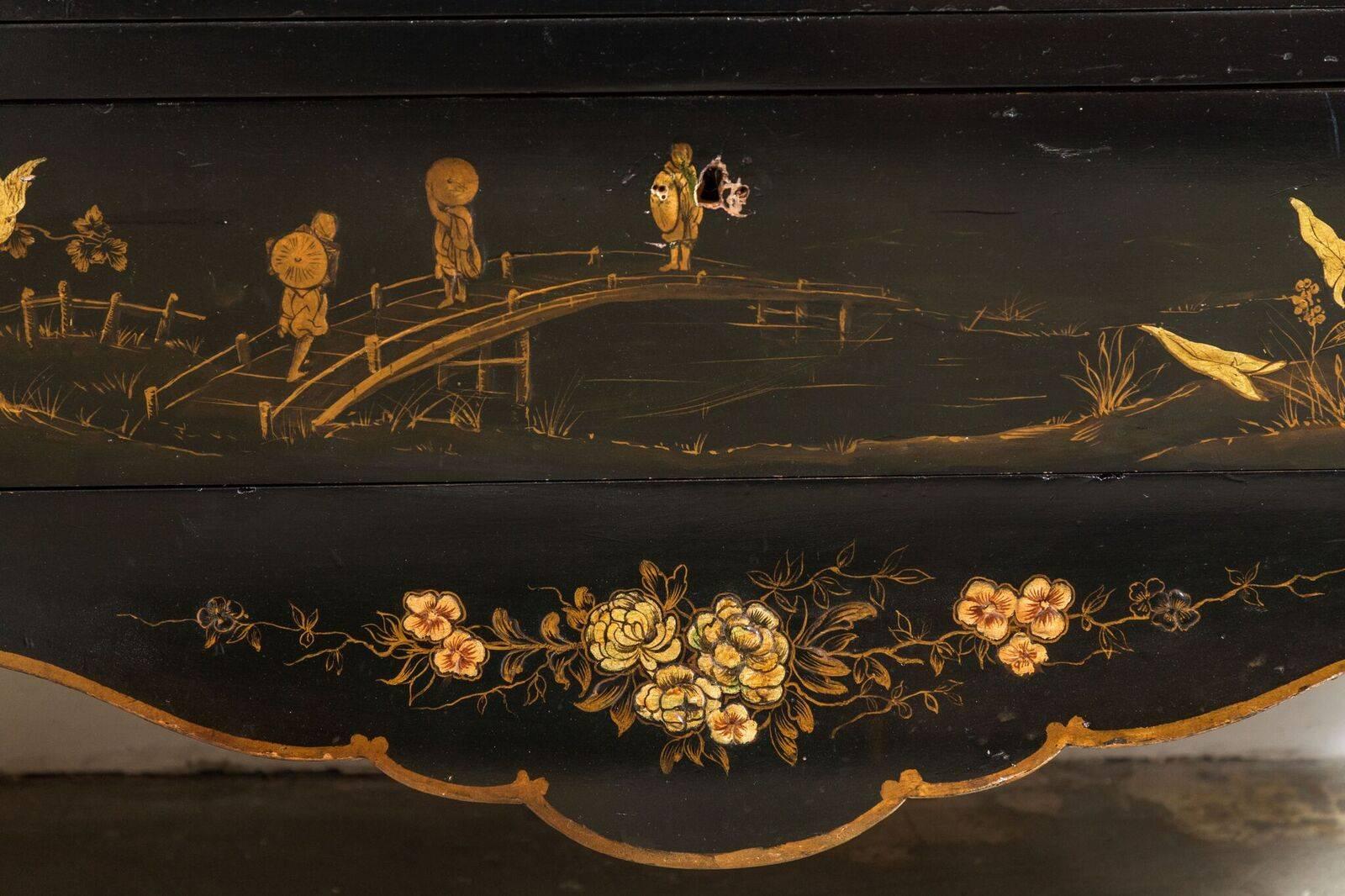 Hand-carved, painted and lacquered three-drawer, raised chinoiserie commode featuring faux-ormolu details. The whole above an elegantly carved apron and petite, cabriole legs.