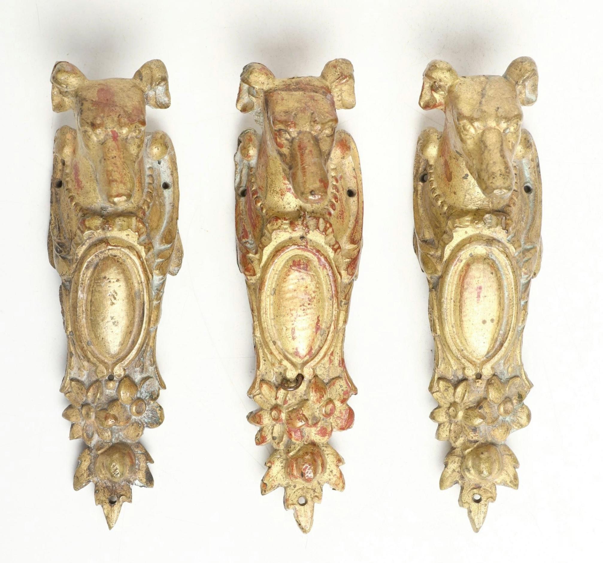 A gorgeous set of three door handles or drawer pulls in bronze with a gilt ormulu finish. They depict a dog’s head. Great detail and casting. Some minor nicks, scratches and gilt loss.