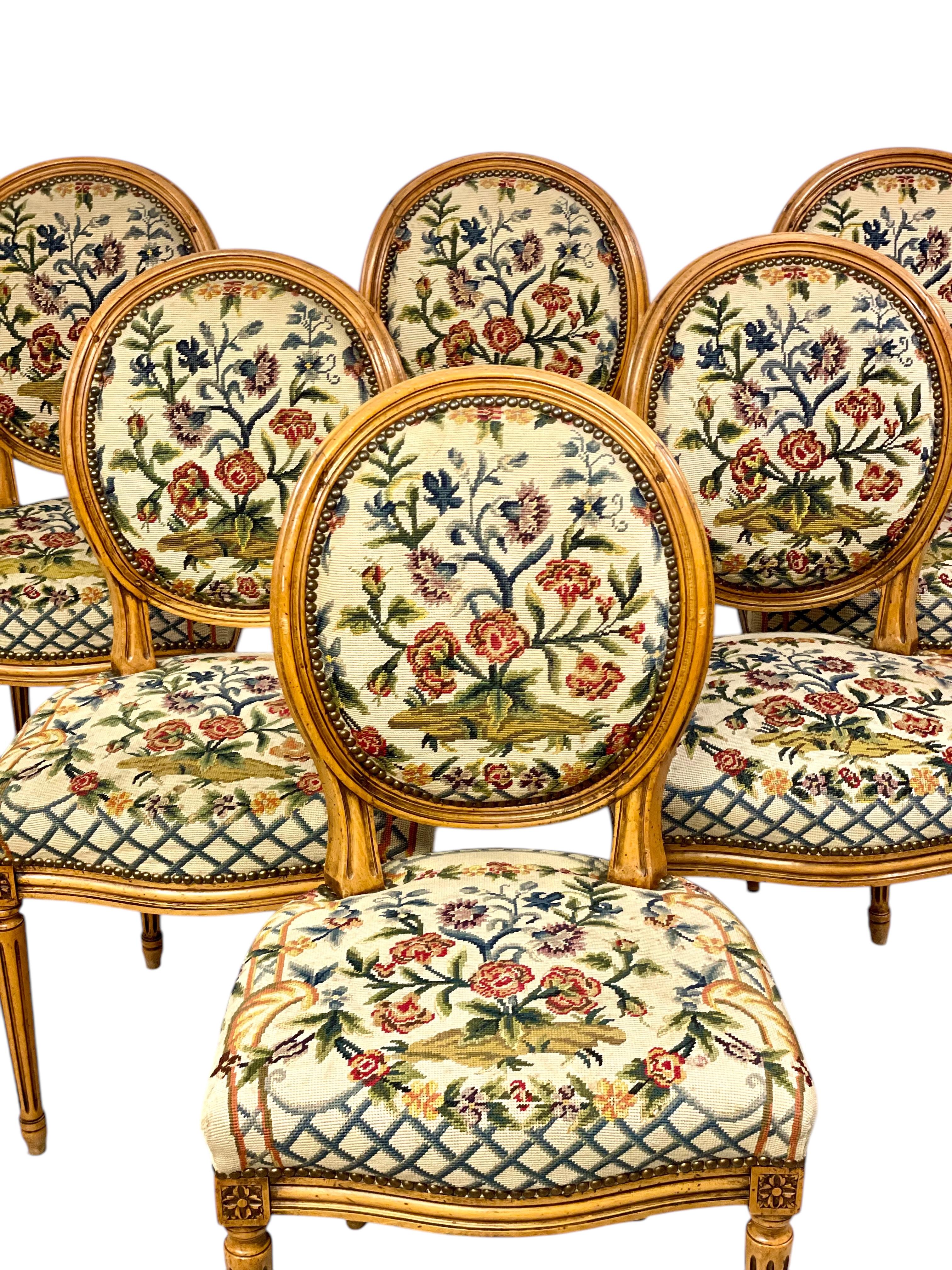 Questo squisito set di sei sedie da pranzo in stile Luigi XVI del XIX secolo è uno straordinario esempio di artigianato ed eleganza francese. Ogni sedia presenta l'iconico schienale a forma di medaglione, incorniciato da legno massiccio finemente