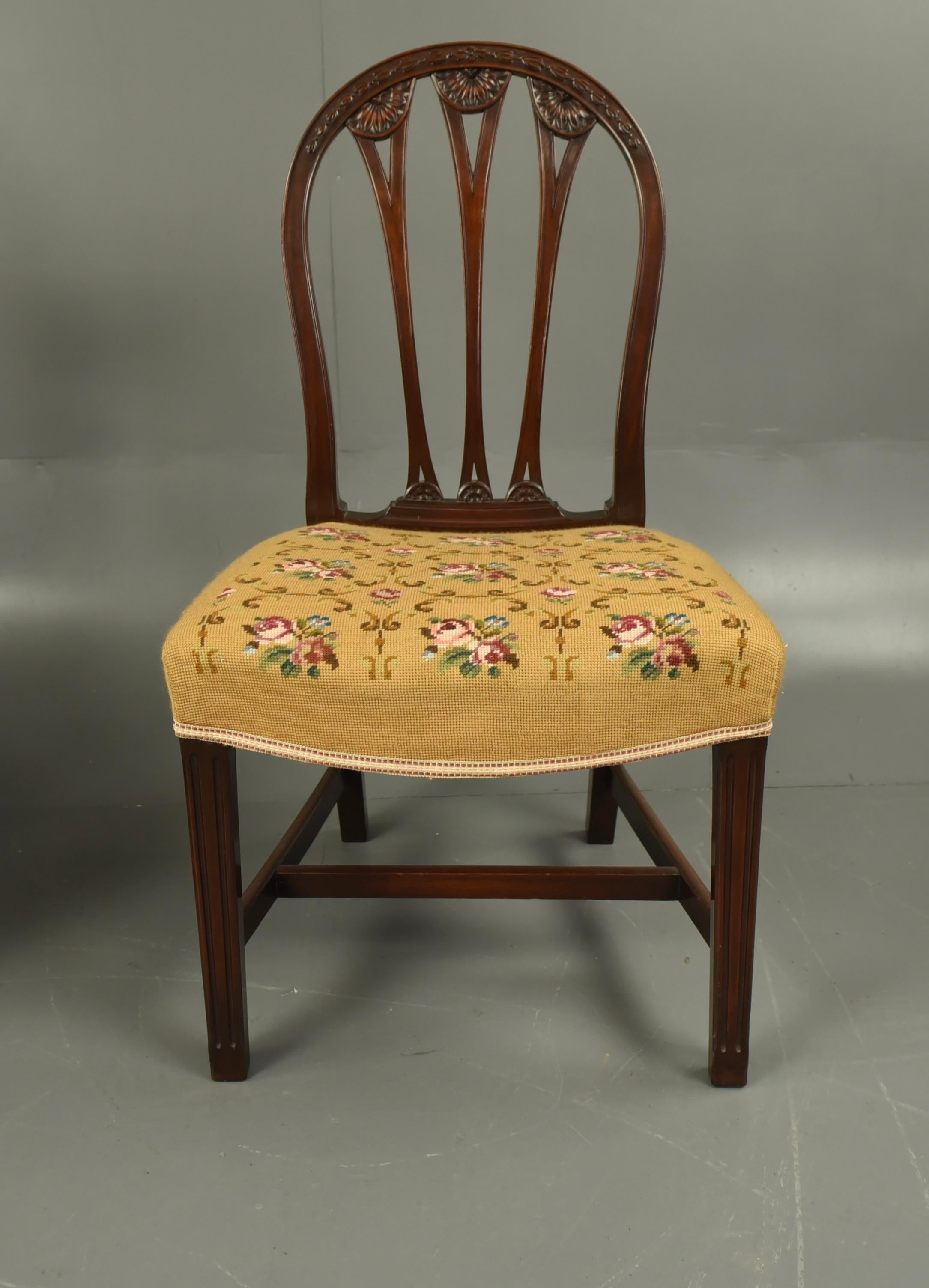 A set of eight late 19th century  mahogany Hepplewhite style dining chairs with fine hand carved  floral backrests raised on tapering legs united by H-stretchers.Upholstered with floral yellow tapestry fabric ,consisting of six single chairs and two