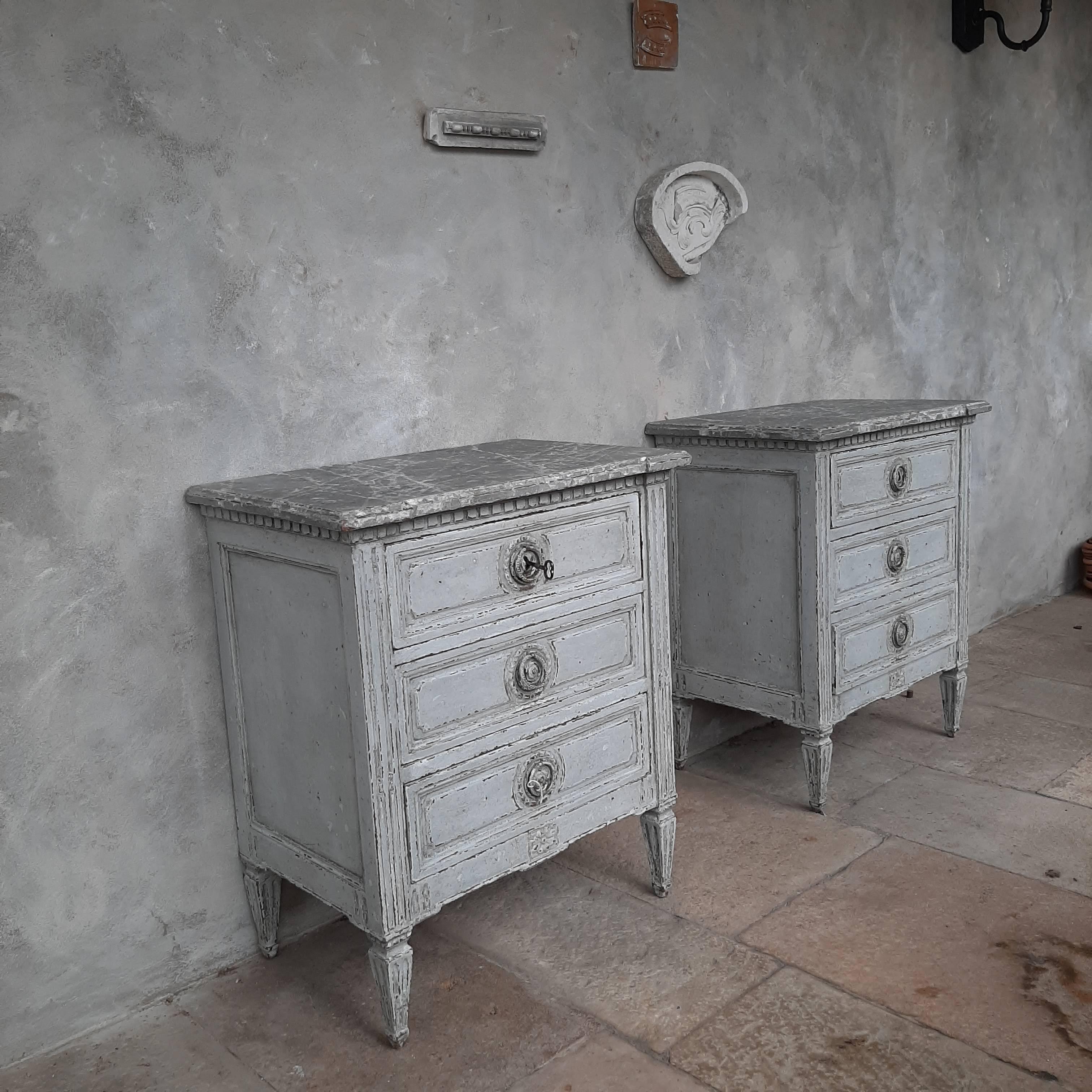 Set of 2 beautiful antique chest of drawers from the 19th century, in Louis XVI style. These bedside tables or cabinets are made of oak and are finished in a beautiful aged grey patina with on the tops a marble look finish. The inside of the drawers