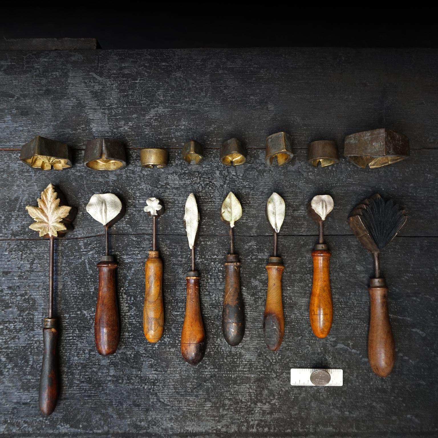 This is a very decorative set of tools from 19th century hat makers. The irons were heated and used to press felt or other fabric in the shape of leaves and flowers to create corsages or decorations on ladies hats. This set is complete with negative