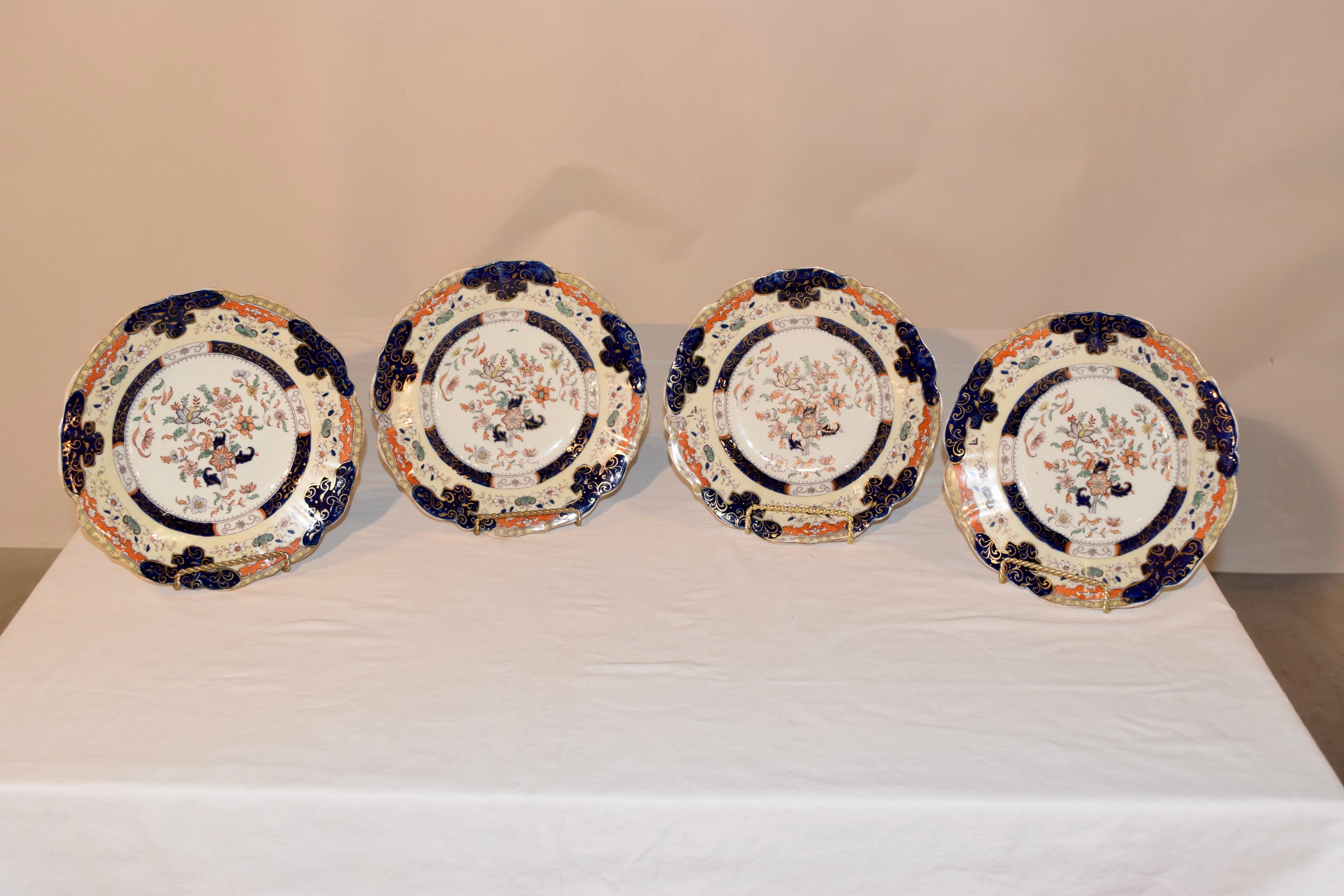 19th century set of four English ironstone plates, signed Mason's over a crown and banner. The plates are transfer decorated in a pattern of florals and vines, and have been hand painted as well.