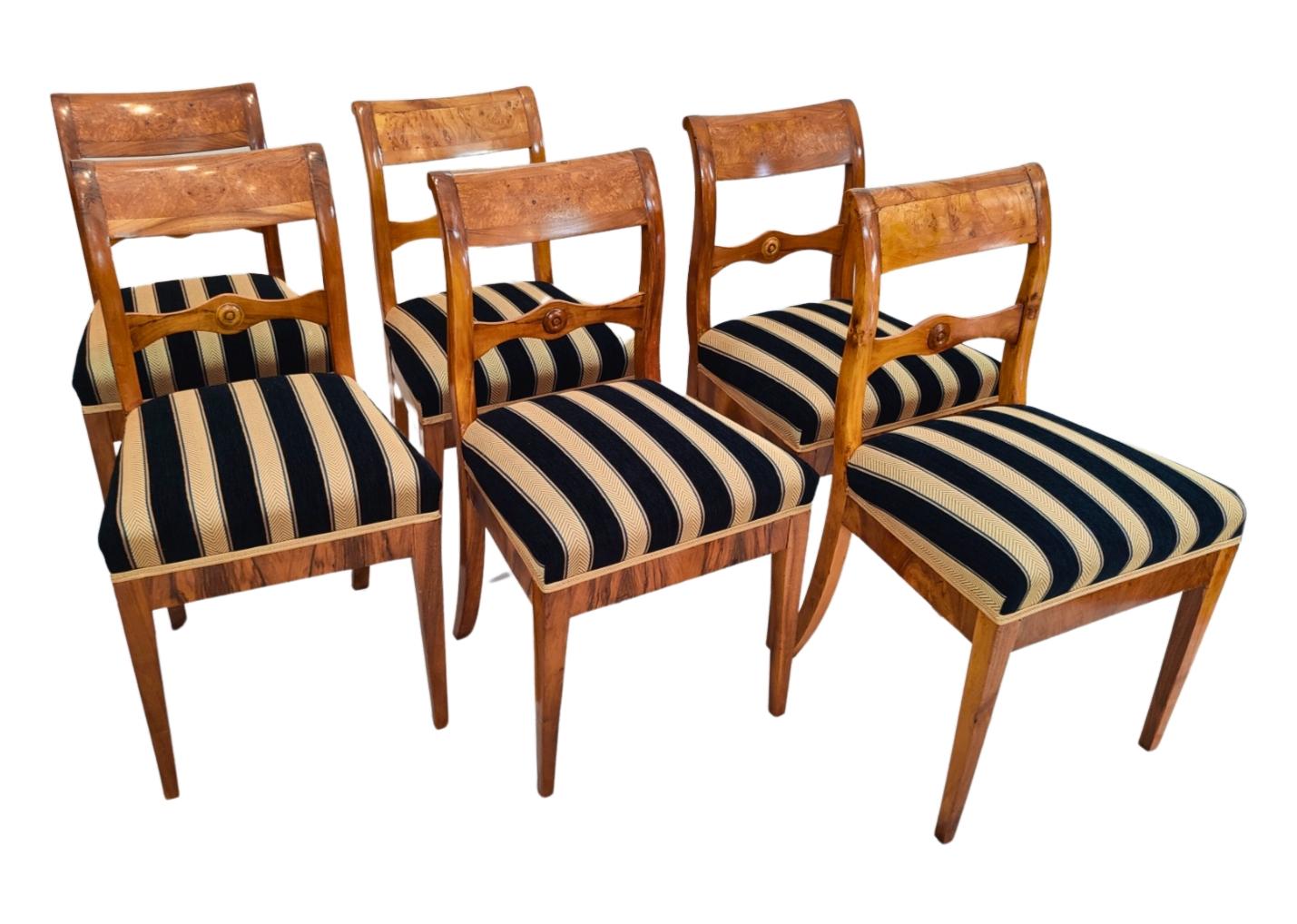 Un set di sei sedie, classico Biedermeier originale, in legno di noce massiccio. Gli schienali presentano un intarsio decorativo in legno di frassino. Splendido e semplice design Biedermeier del 1825 circa. Le sedie sono imbottite e rivestite con