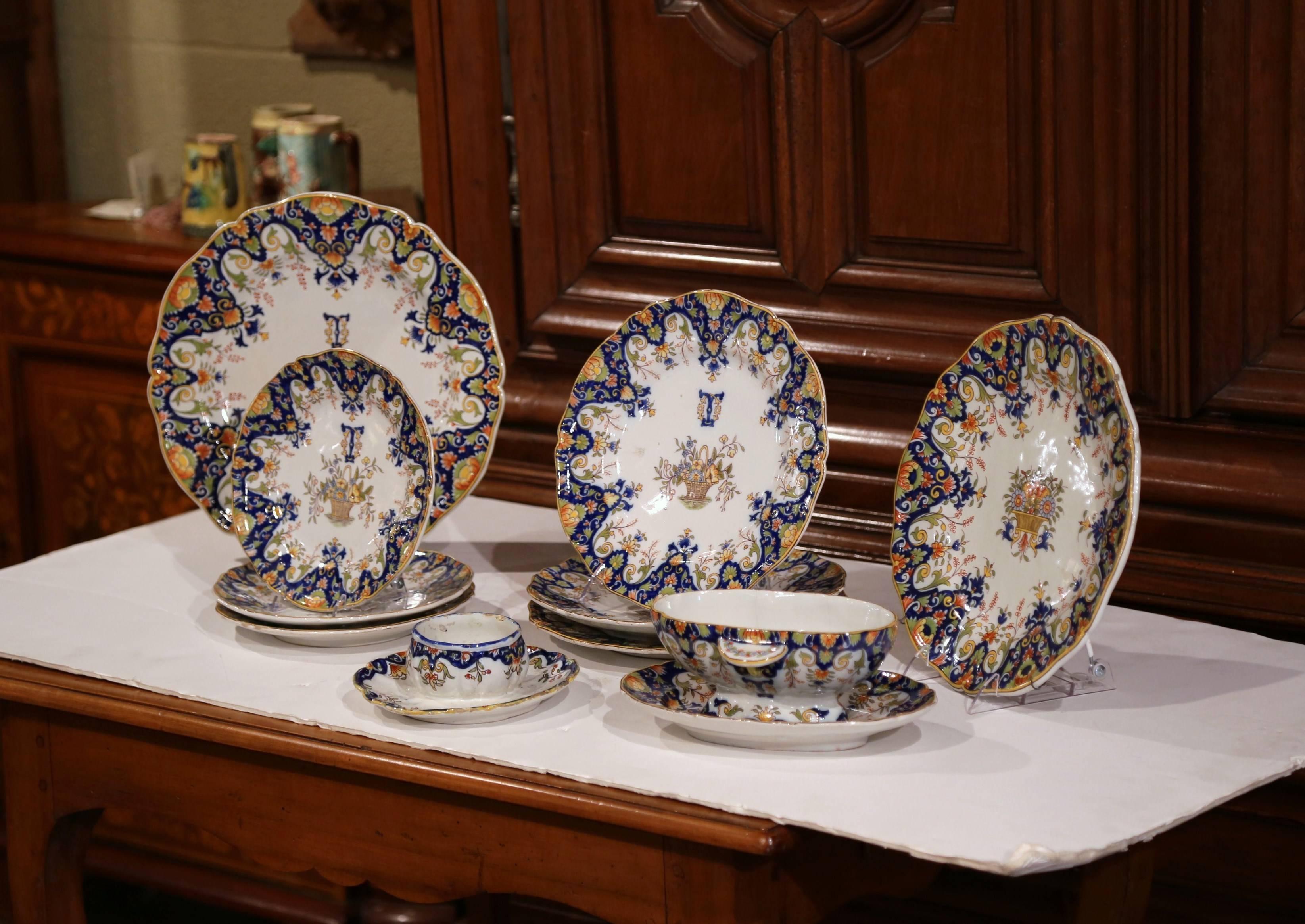 Colorful set of antique wall dishes from Rouen, France, handcrafted, circa 1880, the set includes two large wall hanging platters, six smaller plates, a candleholder and a small bowl. Each ceramic piece features hand painted floral decor in the blue