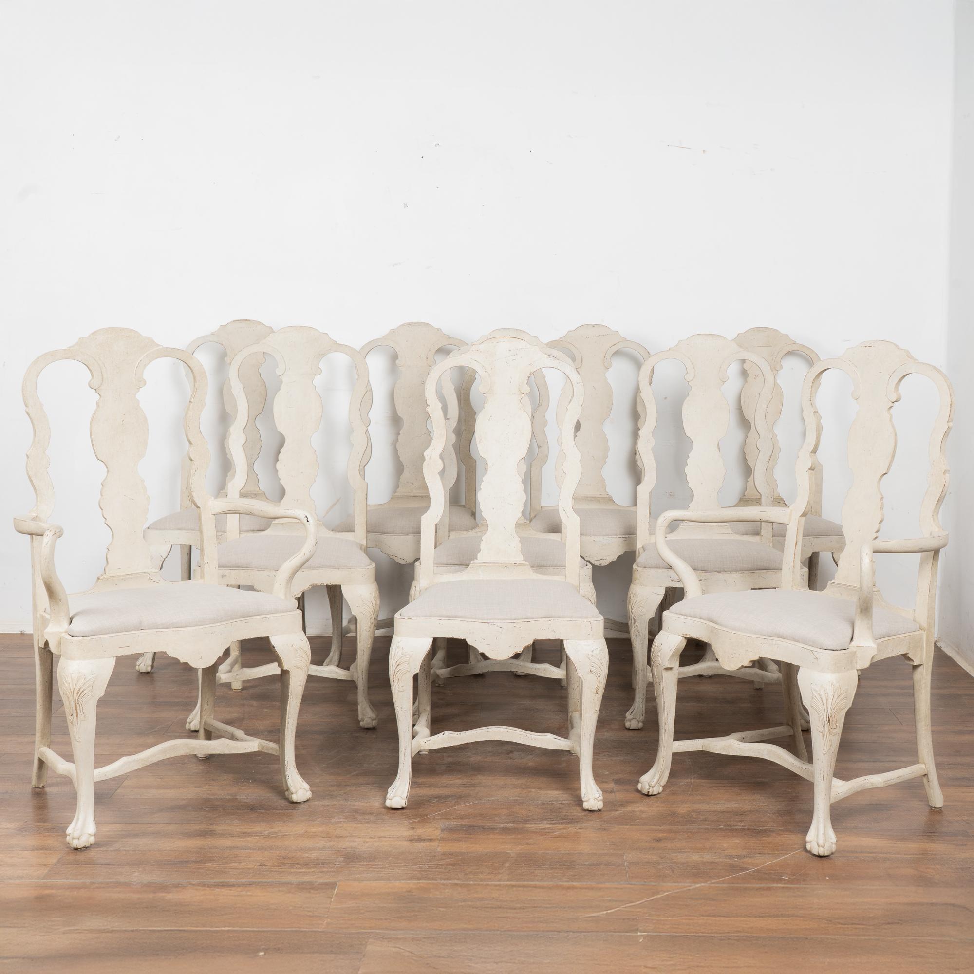 Questo set di dieci sedie da pranzo antiche in pino svedese, tra cui otto sedie laterali e due poltroncine, è caratterizzato da una sobria eleganza in stile rococò.
Schienali con stecche traforate, sedile intagliato e sagomato, gambe a cabriole,