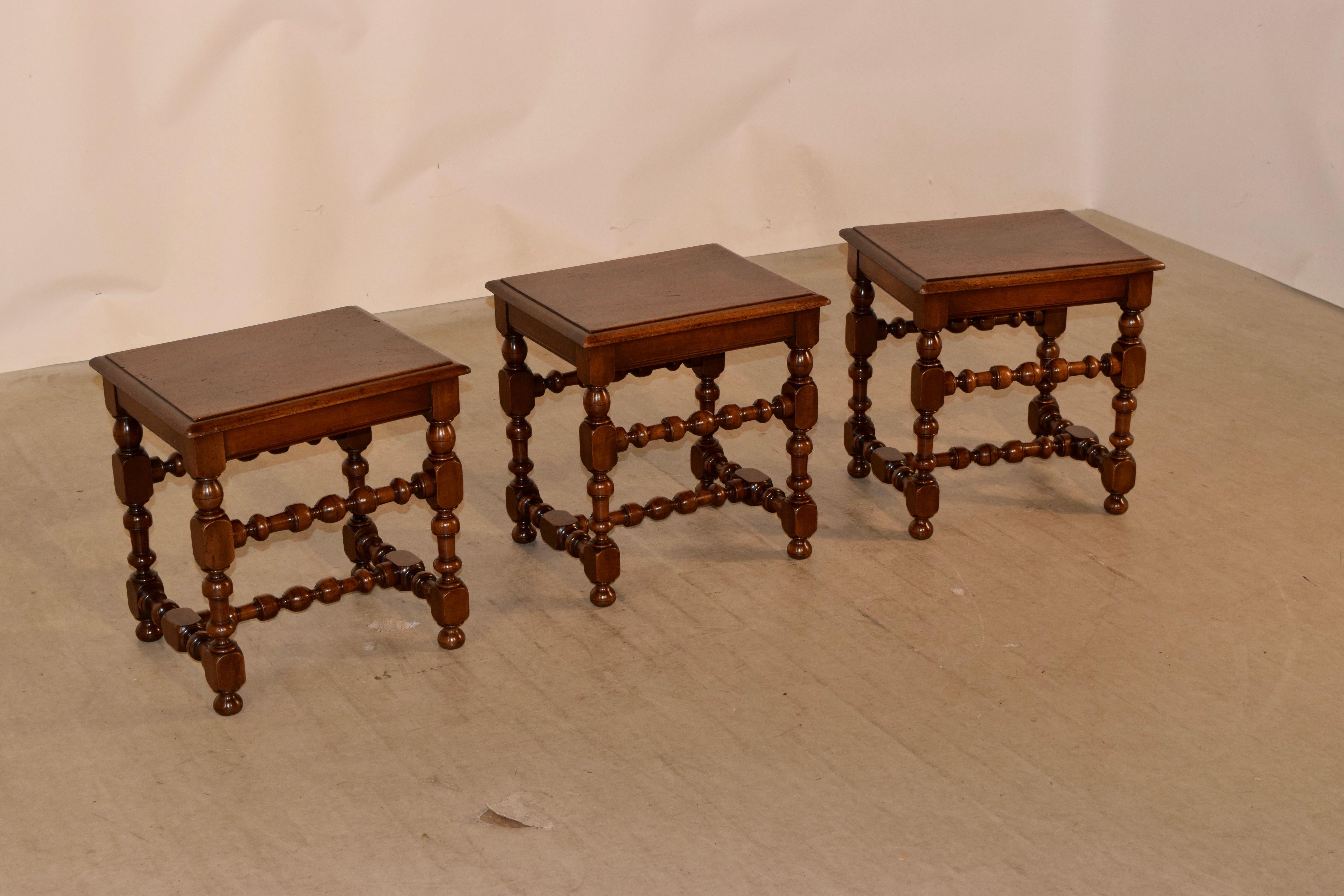 Set of three 19th century walnut stools from France with single plank tops which have beveled edges and simple aprons, supported on hand-turned legs and stretchers and ending in hand-turned feet.