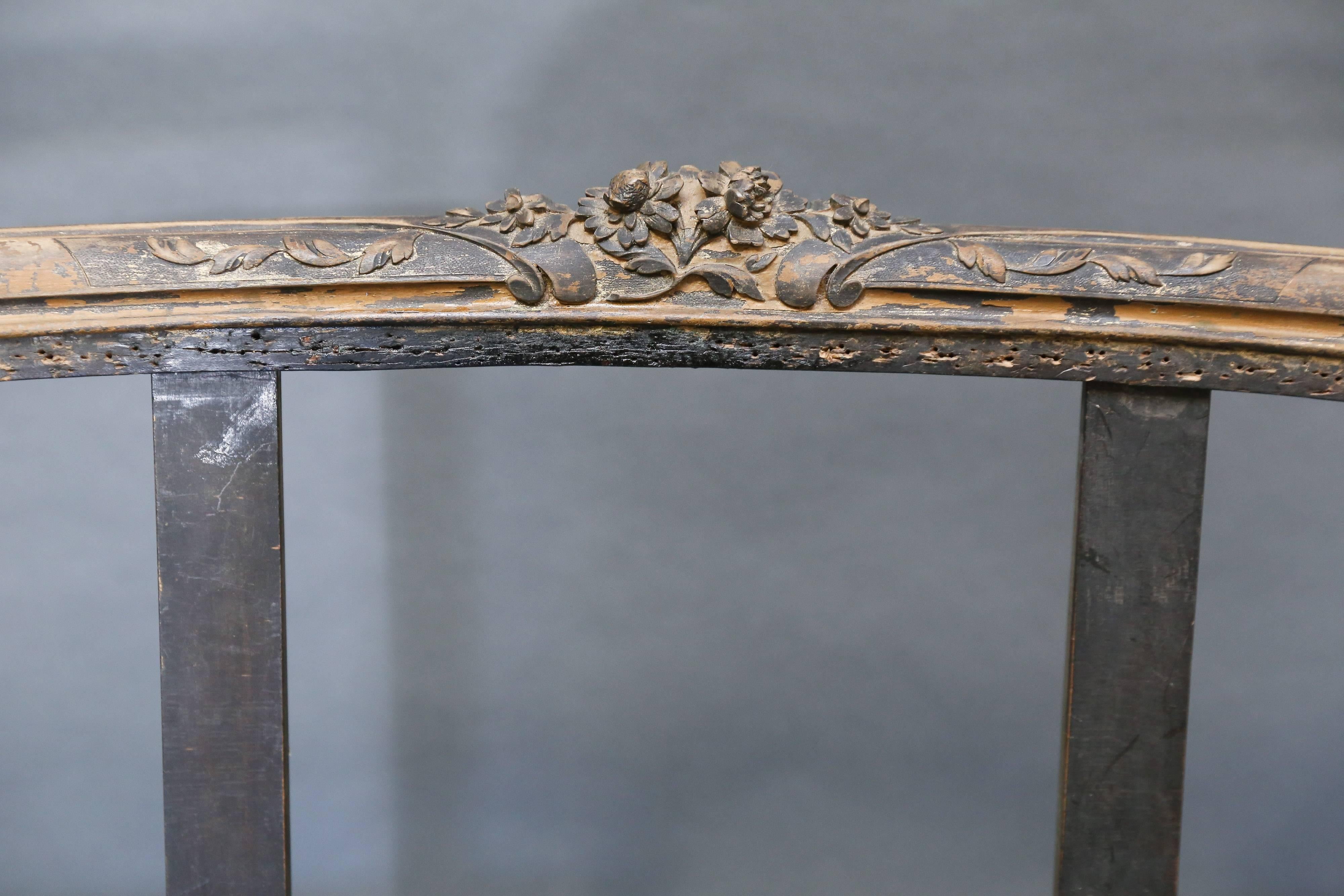 Late 18th century French settee with original paint completely reinforced and ready for reupholstering. Customers are assured that the integrity of the frame is solid. Delicately carved detail at top of crest rail and on seat frame. Shorter arms to
