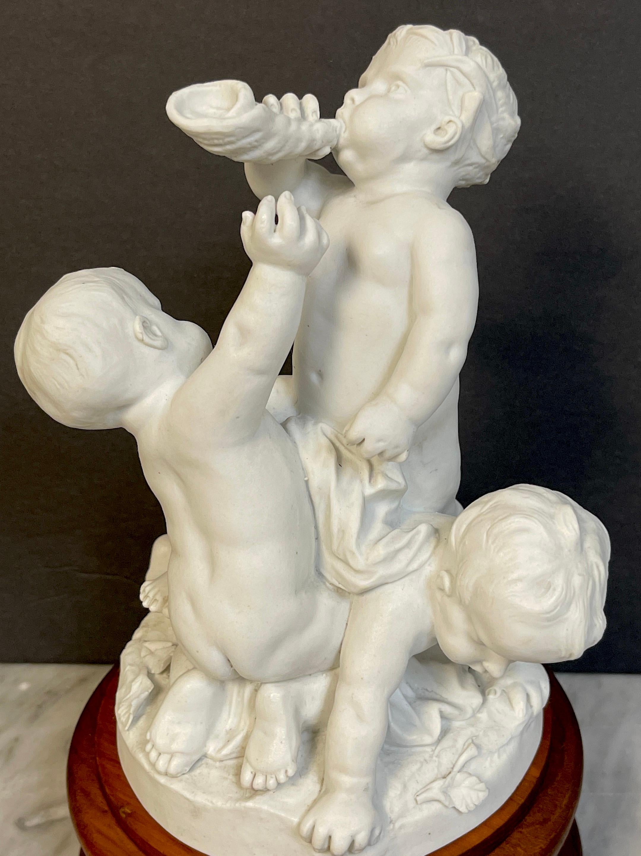 Carved 19th Century Sevres Biscuit Group of Three Frolicking Puttos For Sale