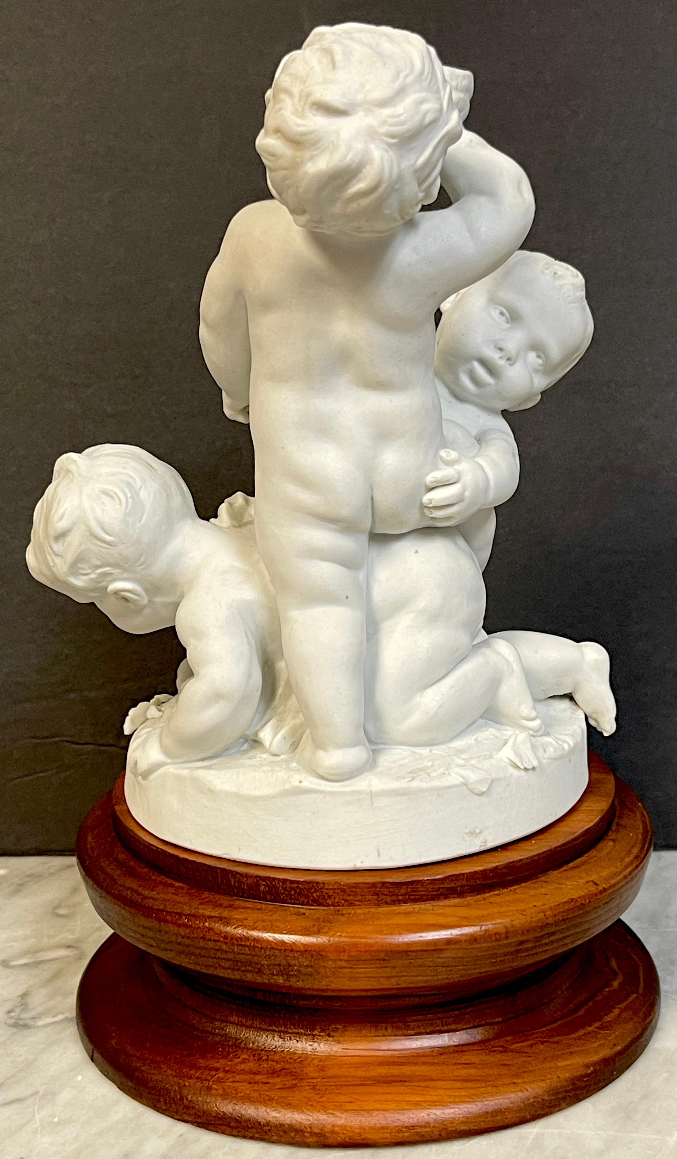 Sculpté Groupe en biscuit de Sèvres du 19e siècle représentant trois puttos en train de s'ébattre en vente
