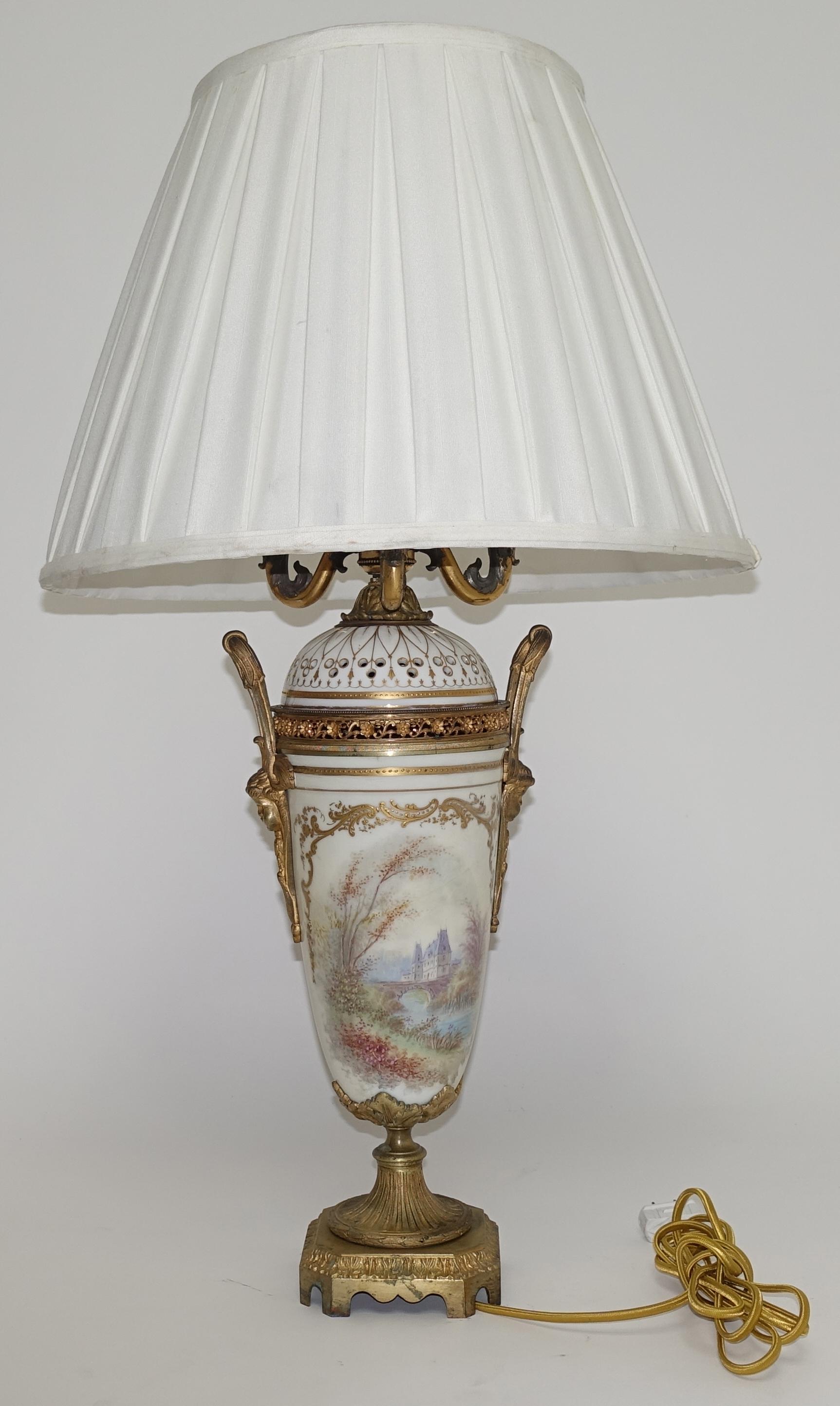 19th century Sèvres ormolu-mounted porcelain urn with cover, later wired for a lamp. The hand-painted urn depicts a couple and a chateau in the countryside.
Marked inside Sèvres 1844 'Chateau des Tulleries'
New wiring.
