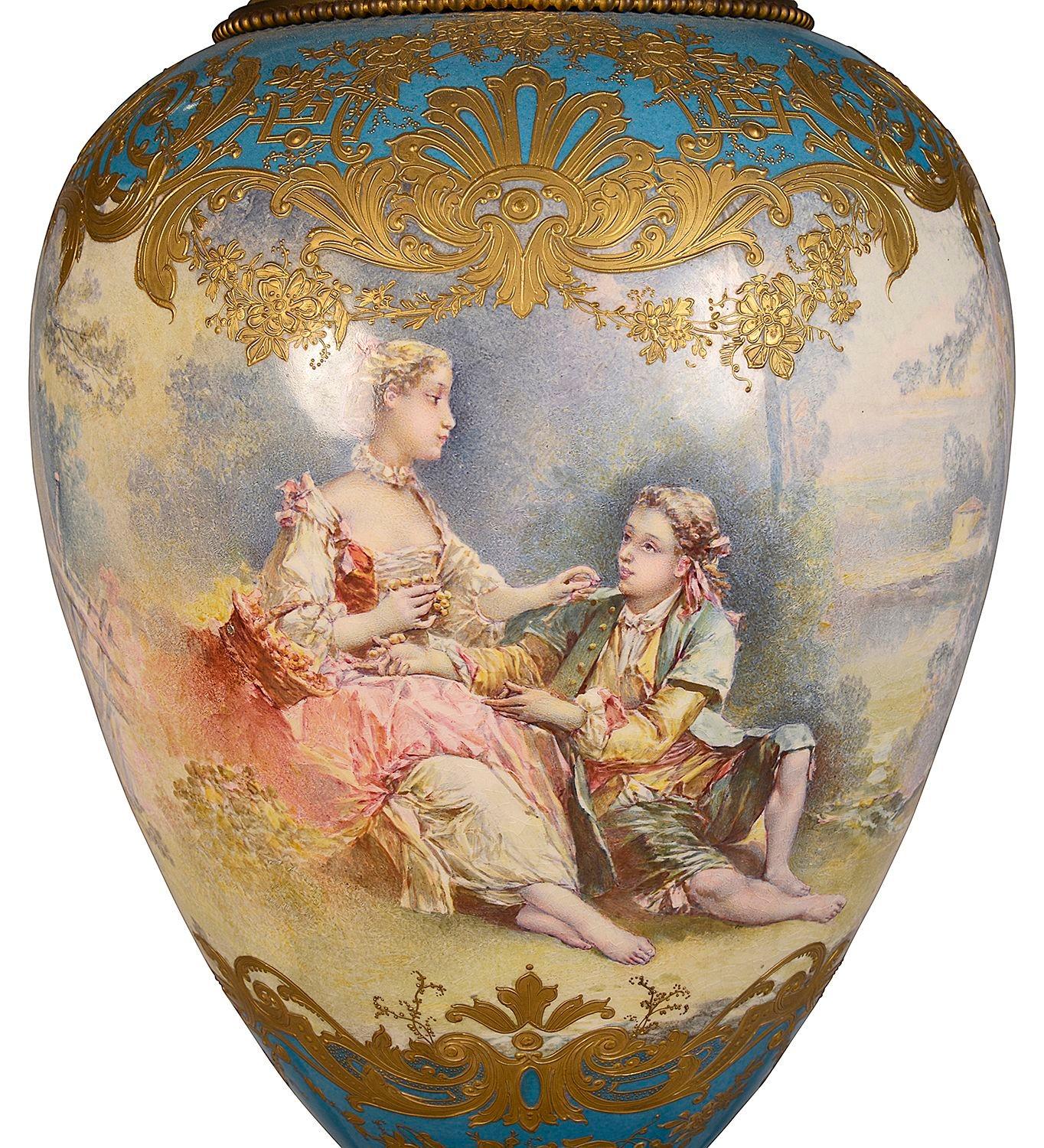A very good quality late 19th Century French Sevres style porcelain lidded vase. Having a turquoise ground, wonderful scrolling gilded decoration, an inset hand painted romantic scene of seated lovers. Mounted with gilded ormolu mounts, a plinth