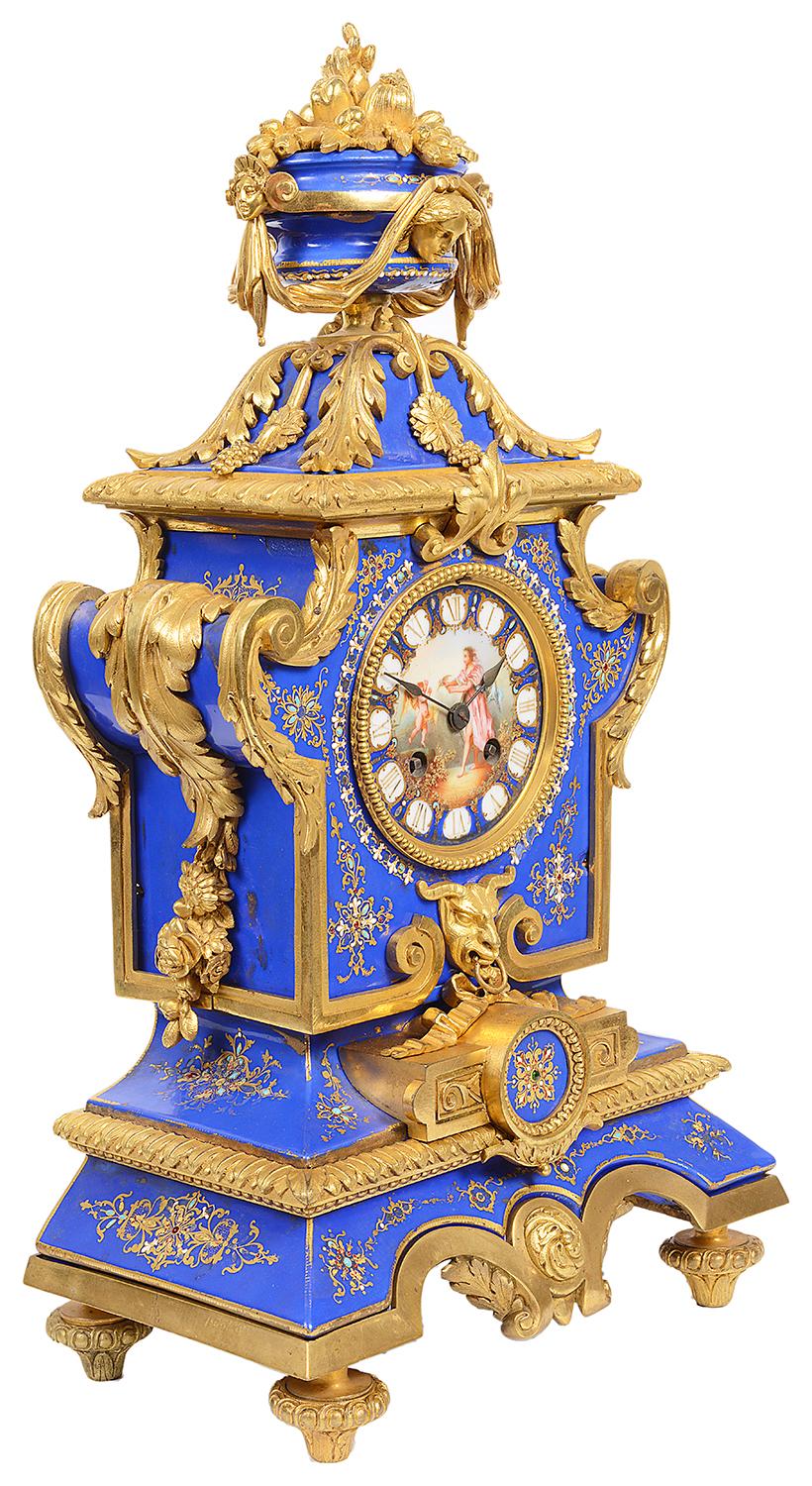 A very good quality 19th century French gilded ormolu and Sevres style porcelain mantel clock. Having a blue porcelain urn to the top with ormolu swags, scrolling gilded ormolu foliate mounts, porcelain inset panels with gilded motif decoration. The