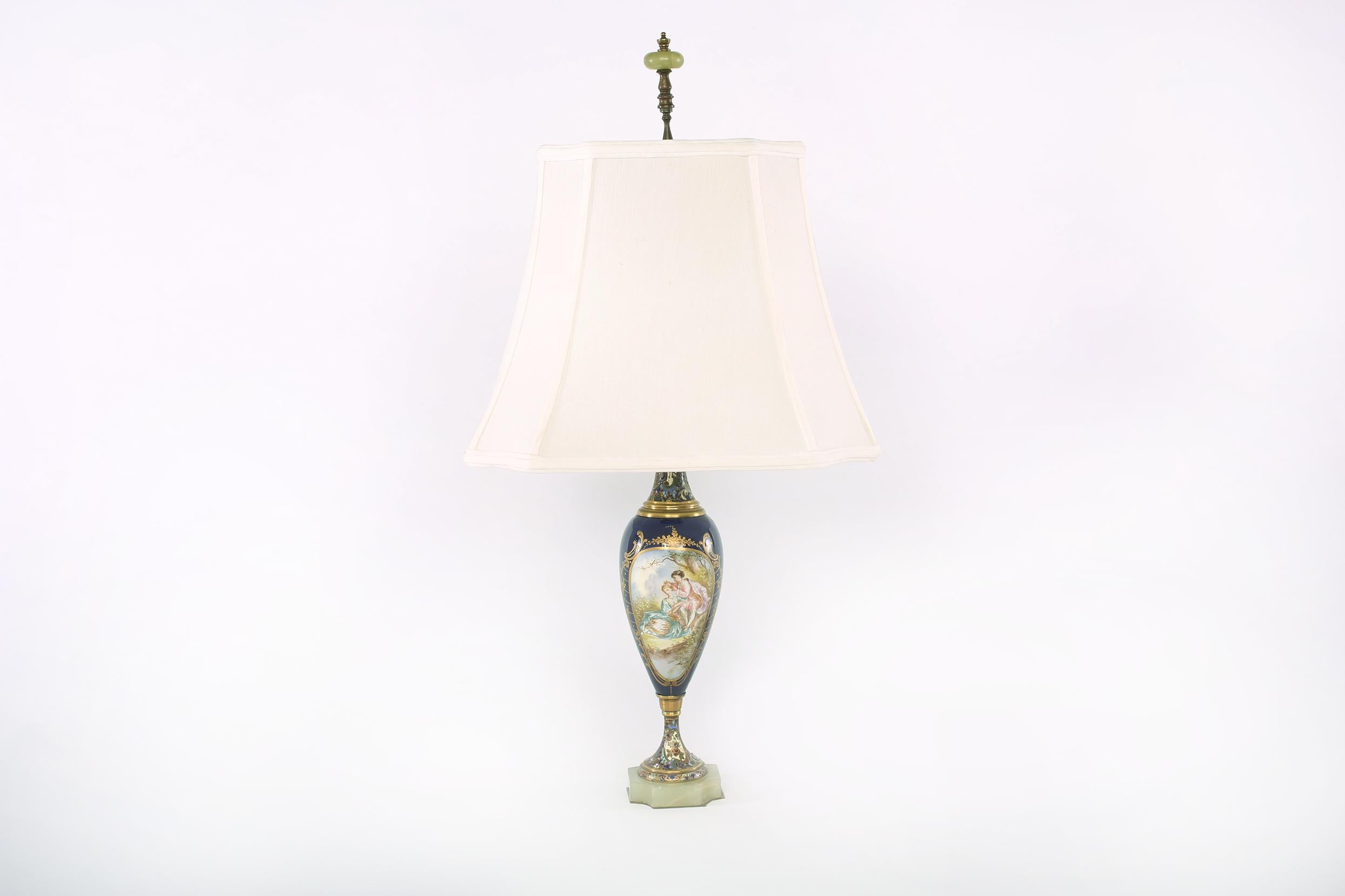Sèvres style with gilt metal mounted porcelain urns shape pair table lamps over a canted square onyx base, with exuberantly painted design details and foliate motifs. Each lamp is in good working condition with appropriate wear consistent with age /