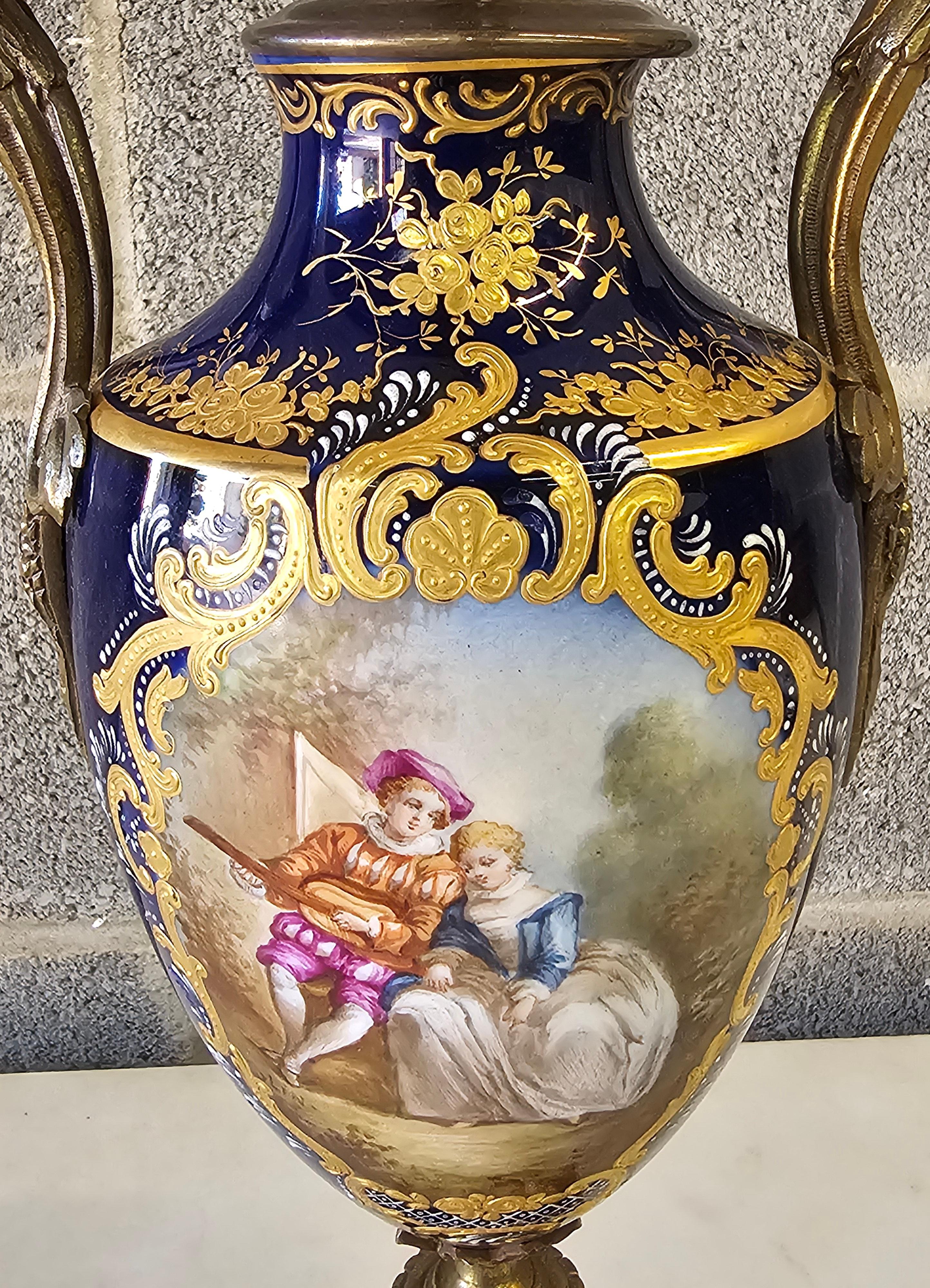 19th Century Sevres Type hand Painted, Gilt Porcelain and Ormolu Mounted dual handled Vase Table Lamp with original harp and figural painted porcelain finial. Light bulb socket likely a replacement.
Measures 6
