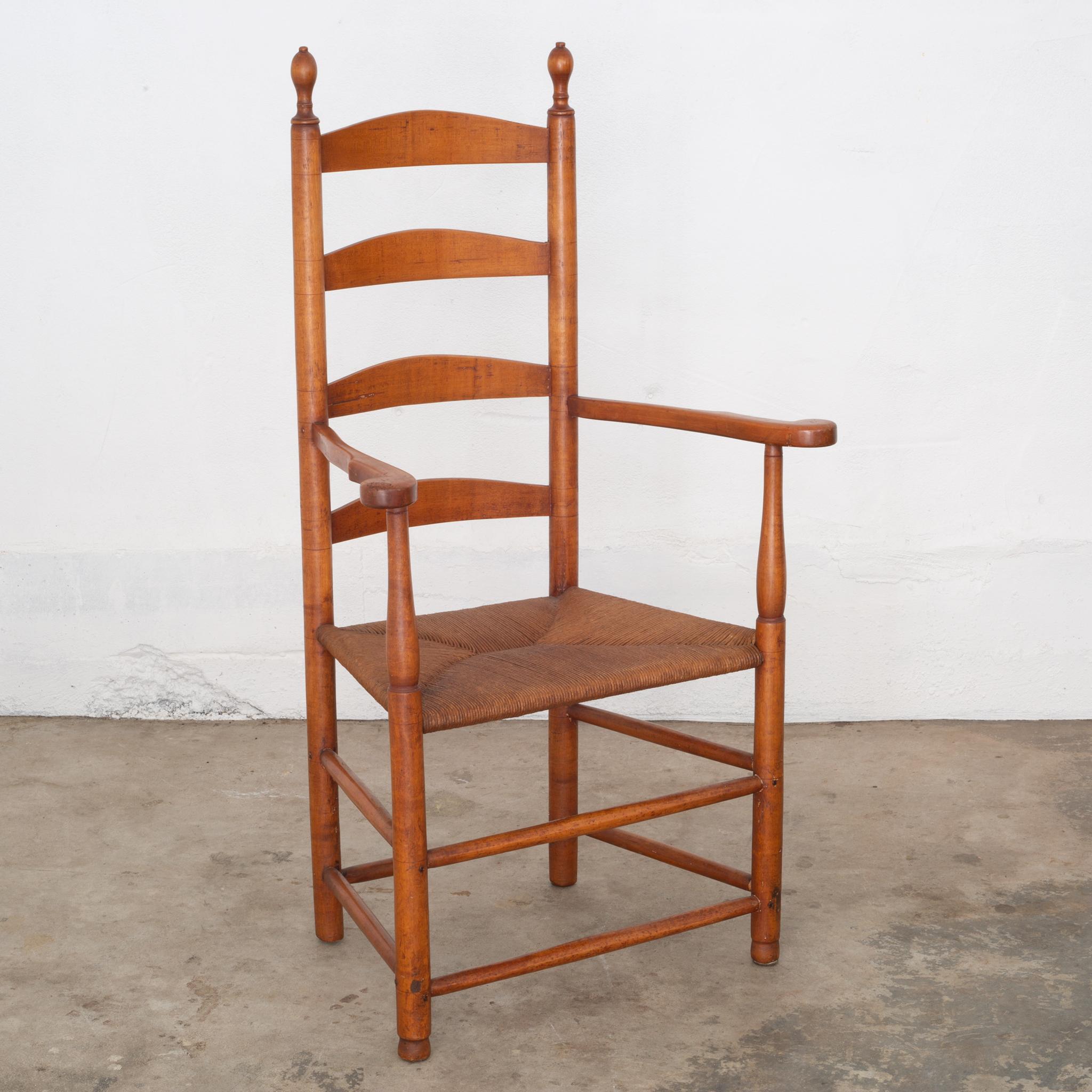 An antique shaker elder's ladder back armchair from the Mount Lebanon Shaker Community of New York with original scribing lines and wooden pegs. The chair has worn, flat marks on the back due to the common practice of hanging of the chair on the