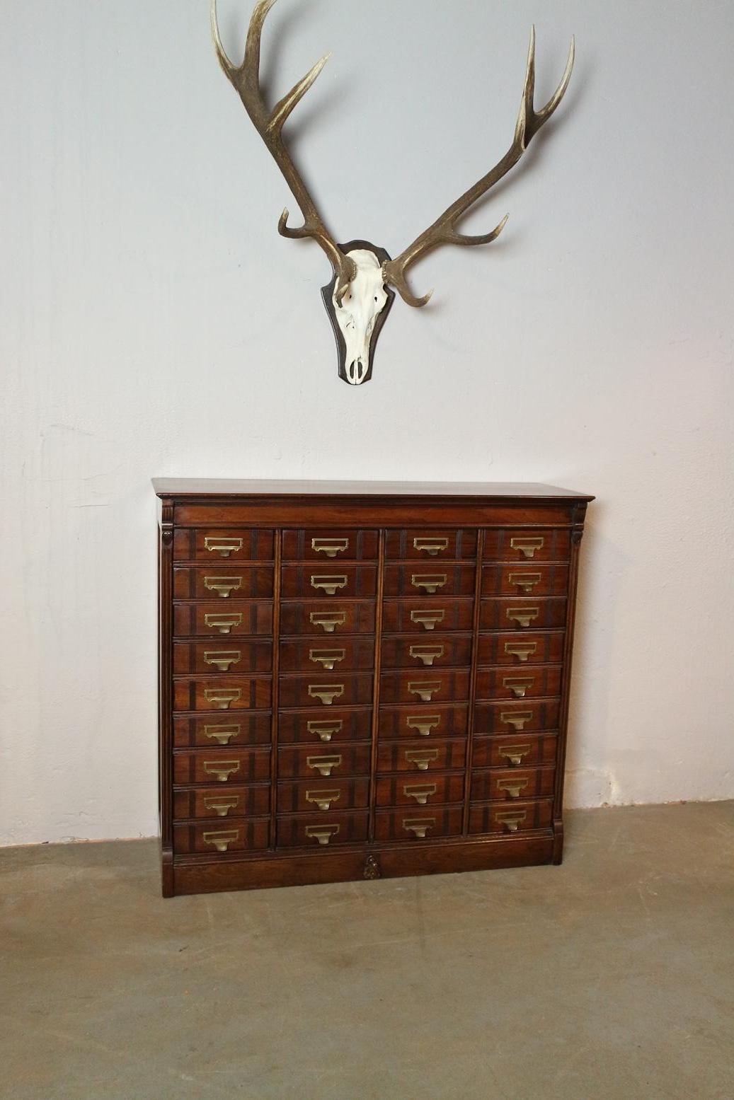 Antique walnut filing cabinet from the well-known US firm Shannon. They also had a European branch in London. This is a filing cabinet with 36 drawers and can be locked by a central locking (bottom center) no key present. The filing cabinet is