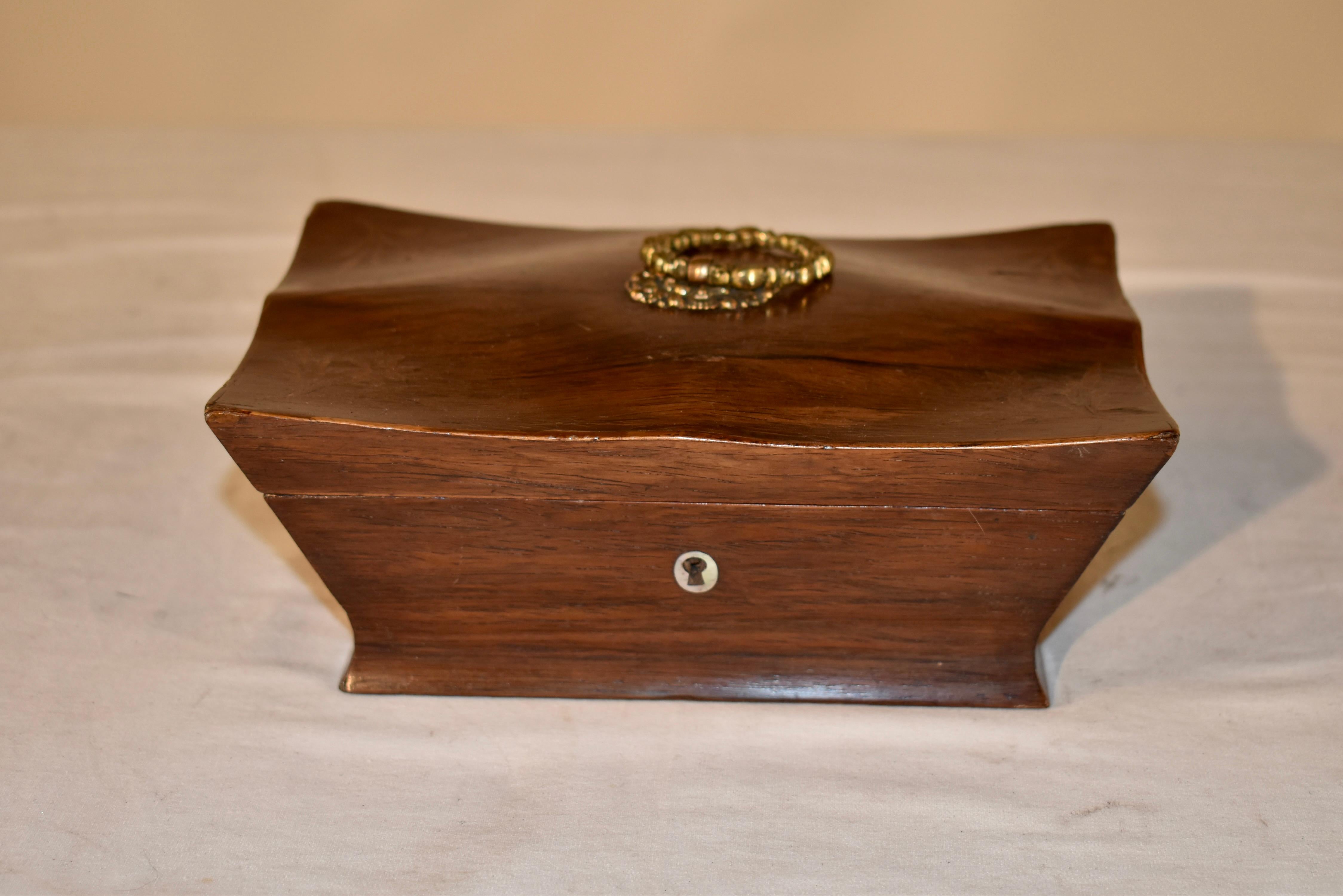 Coffret d'époque en bois de rose.  Le couvercle a une forme gracieuse et une poignée en laiton coulé à la main sur le dessus.  Le mouvement du sommet semble presque liquide.  Dans les coins du plateau, une belle incrustation de fleurs en bois satiné
