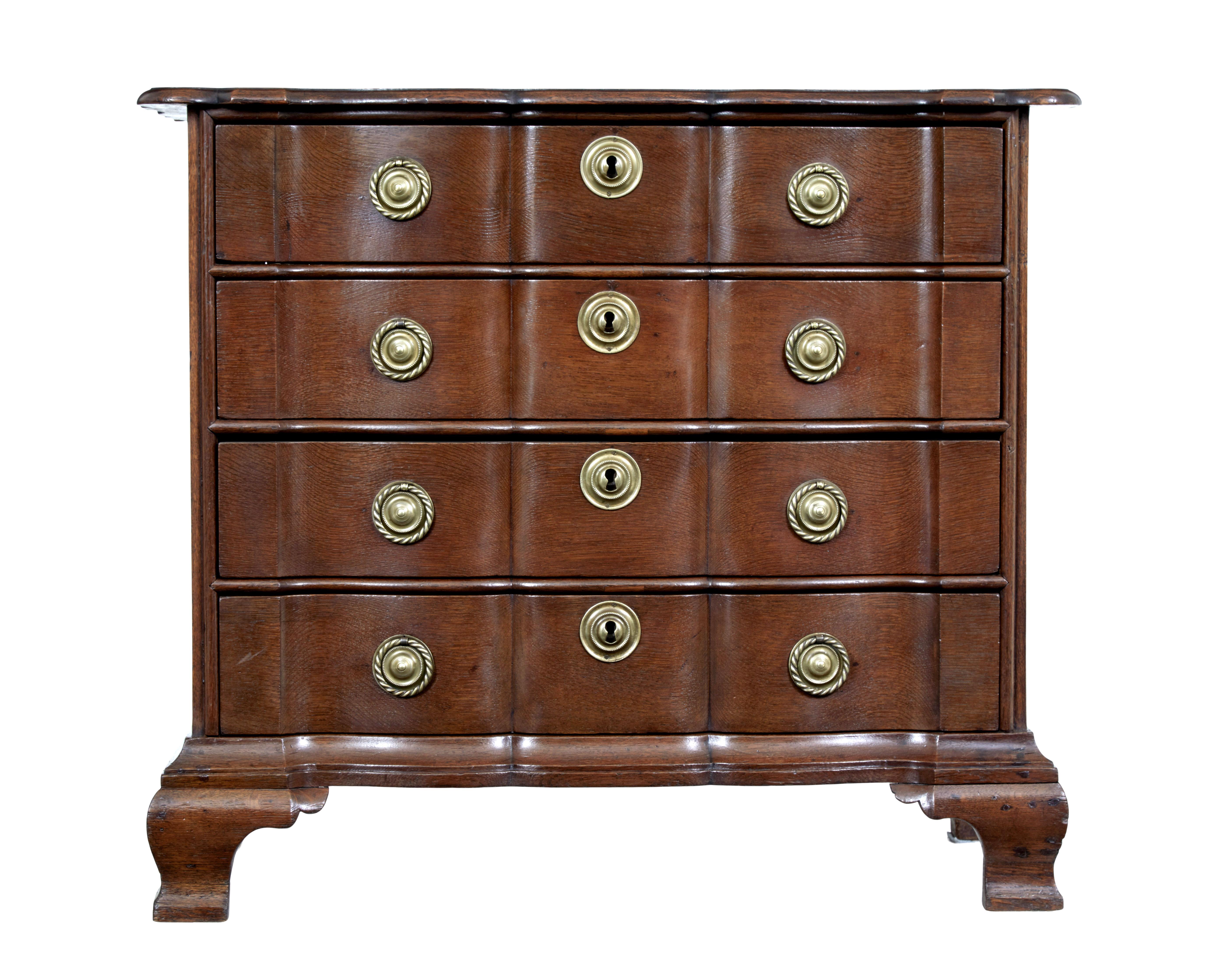 19th century shaped front oak chest of drawers circa 1880.

Dutch shaped oak chest of drawers commode with its serpentine fronted commode very much in the dutch taste. 4 drawers with original brass rope ring handles and escutcheons.

Standing on