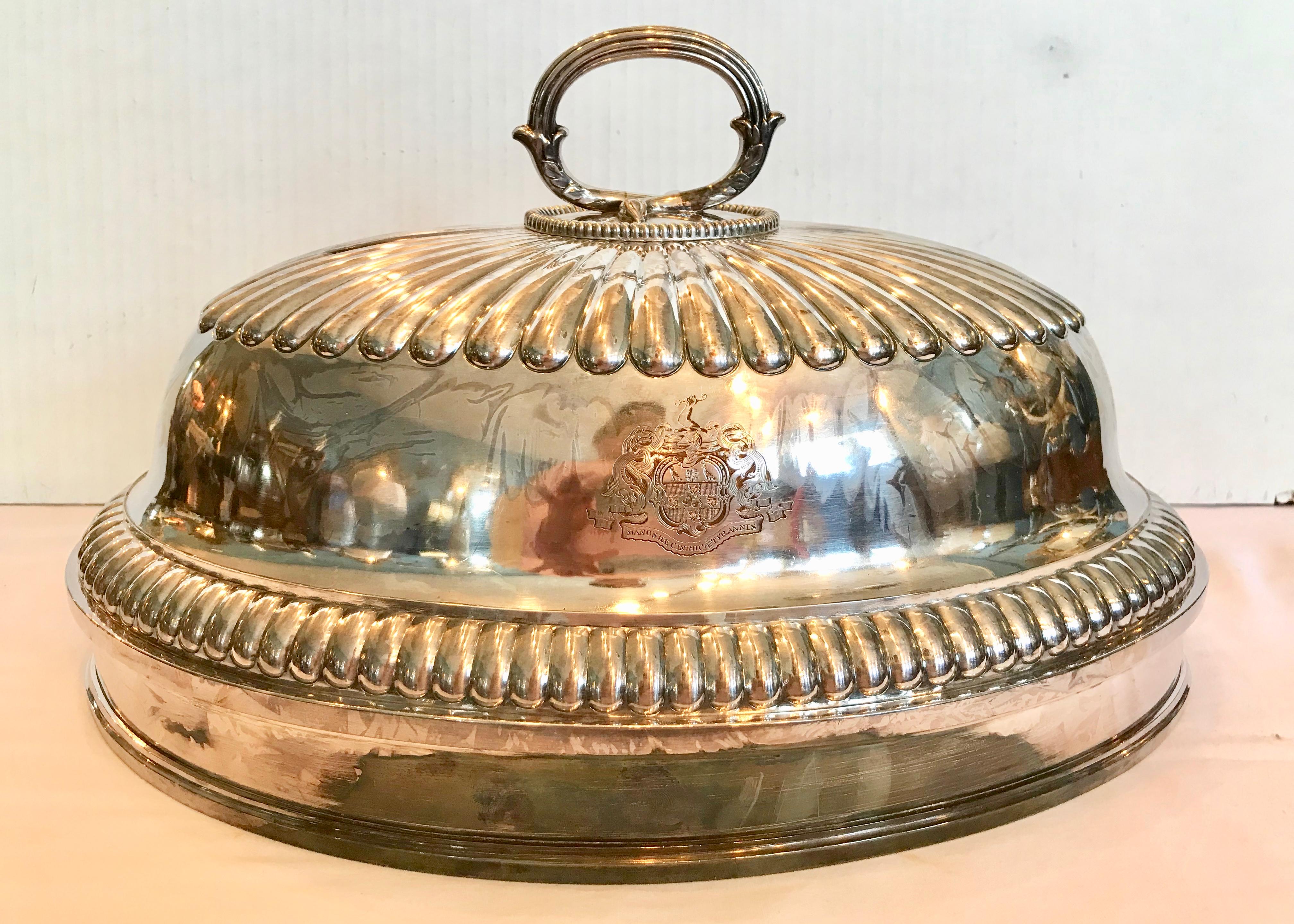 Fashioned with a reeded top and sides. The dome is appointed with a twig-like handle 
and is decorated with a coat of arms featuring a rampant lion in its center.