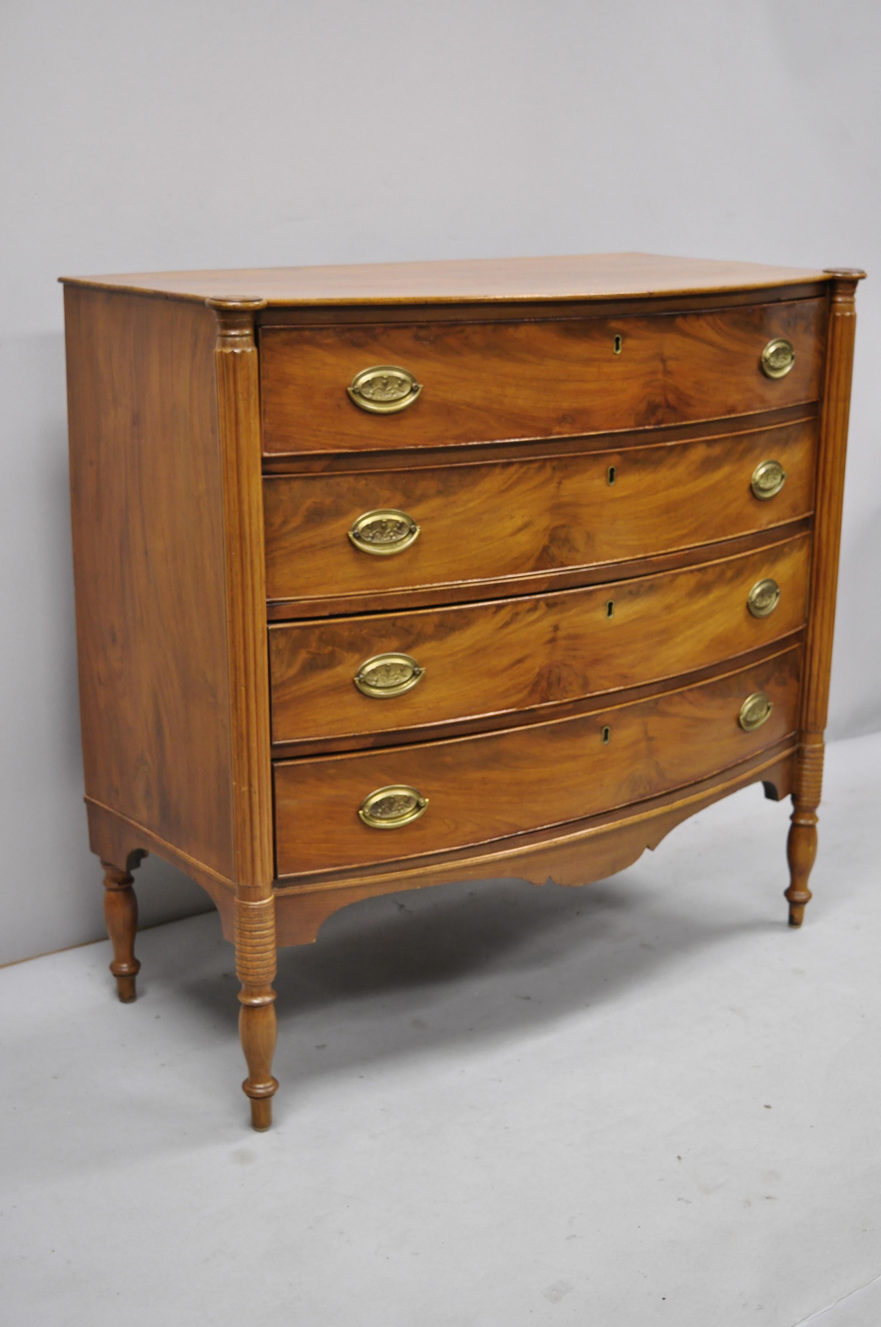 19th century Sheraton 4-drawer mahogany bow front bachelor chest drawer. Listing includes beautiful wood grain, nicely carved details, no key, but unlocked, 4 drawers, tapered legs, solid brass hardware, very nice antique item, quality