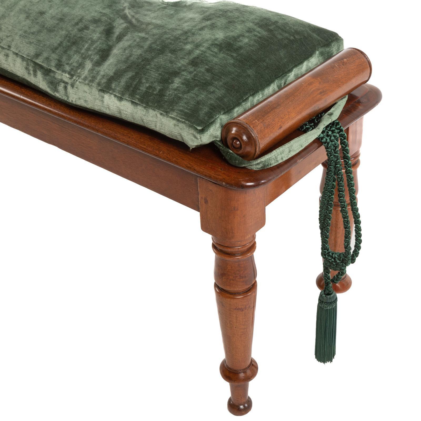 Eine Mahagoni-Dielenbank aus dem 19. Jahrhundert im Sheraton-Stil, die sich durch ihre fein geschnitzten, gerollten Arme und elegant gedrechselten Beine auszeichnet und mit einer warmen, gut gealterten Patina versehen ist. Ergänzt wird es durch ein