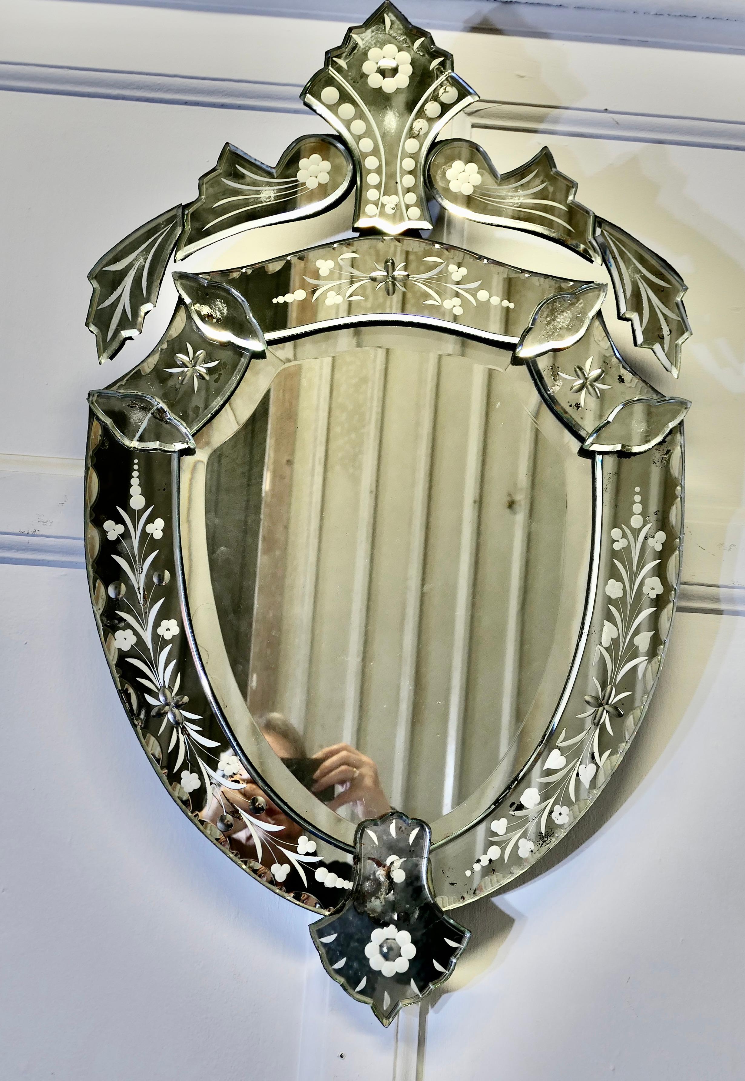 19th Century Shield Venetian Mirror

This is a very unusual piece, it is in the shape of a shield, it has floral etching on all the frame surfaces and it has bevelled glass at the centre
The Mirror is in very good condition with only slight loss to